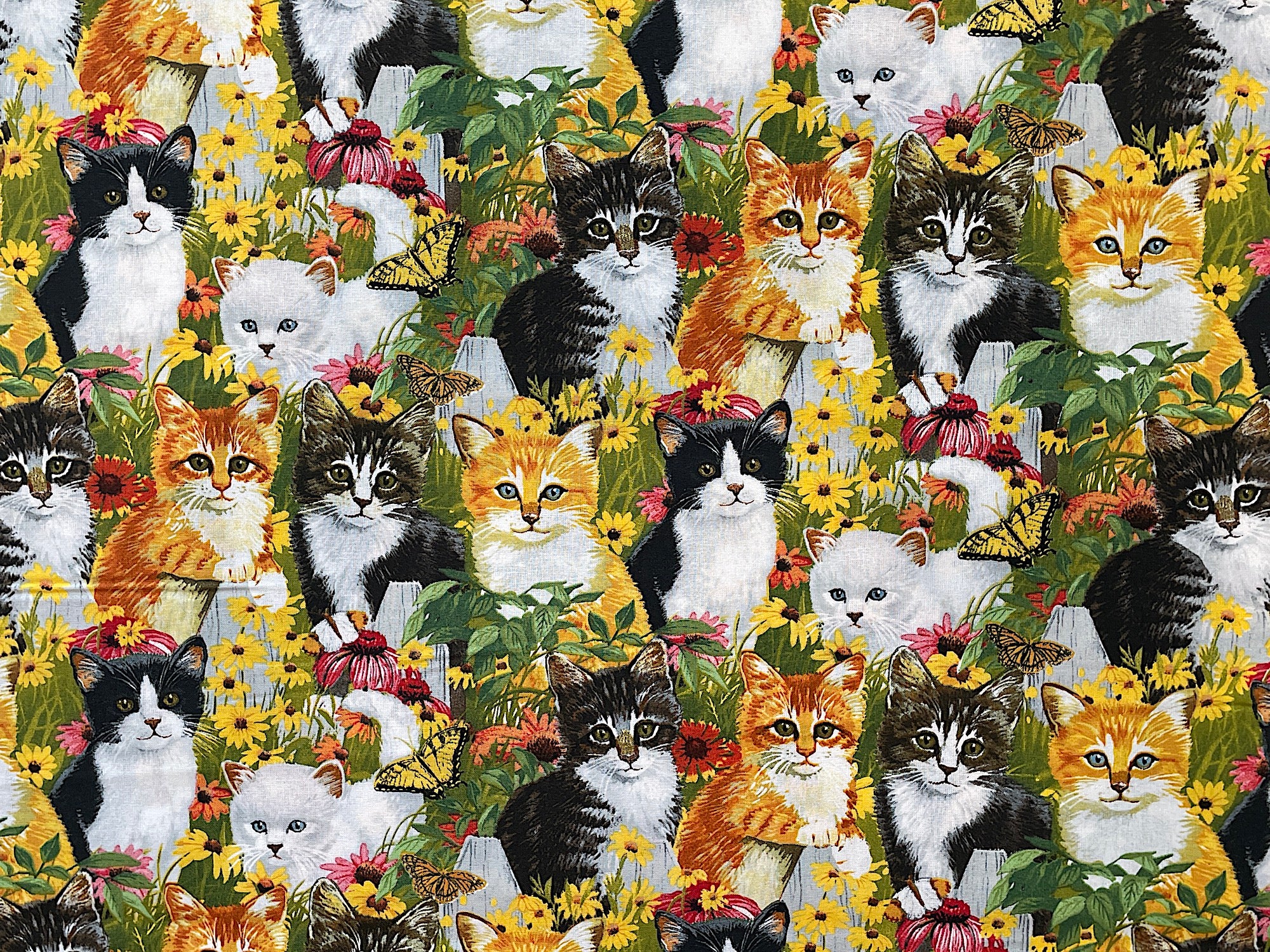 Cotton fabric covered with white, black and yellow cats.