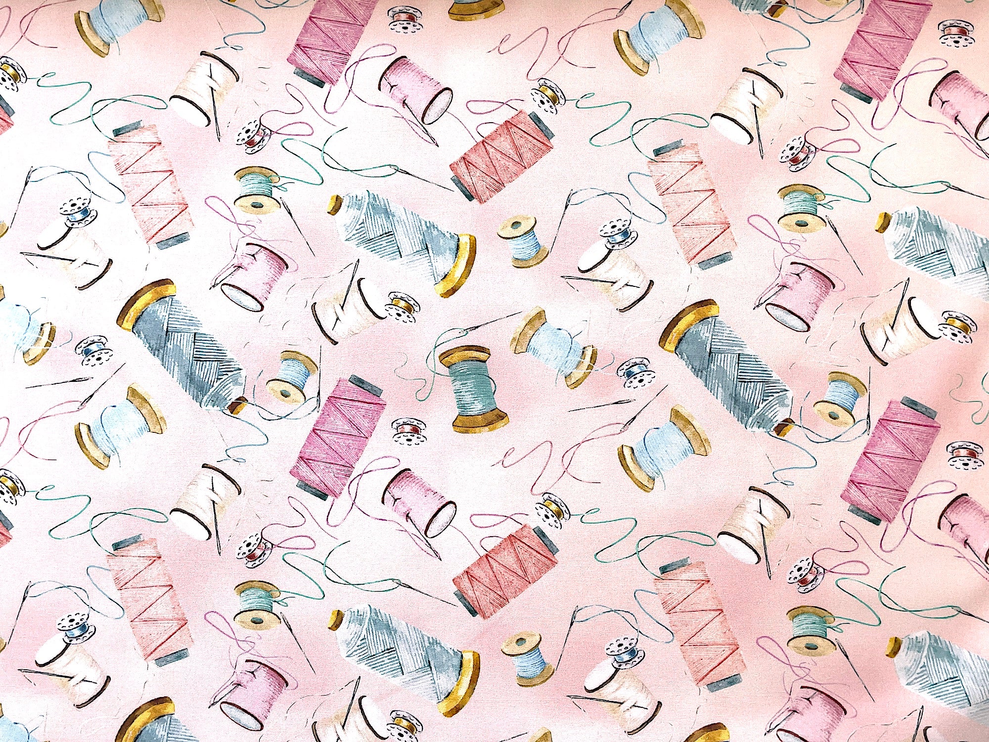 This fabric is part of the Sew in Love Collection by Rockstar Sewing.  This light pink cotton fabric is  covered with spools of thread, bobbins and sewing needles.