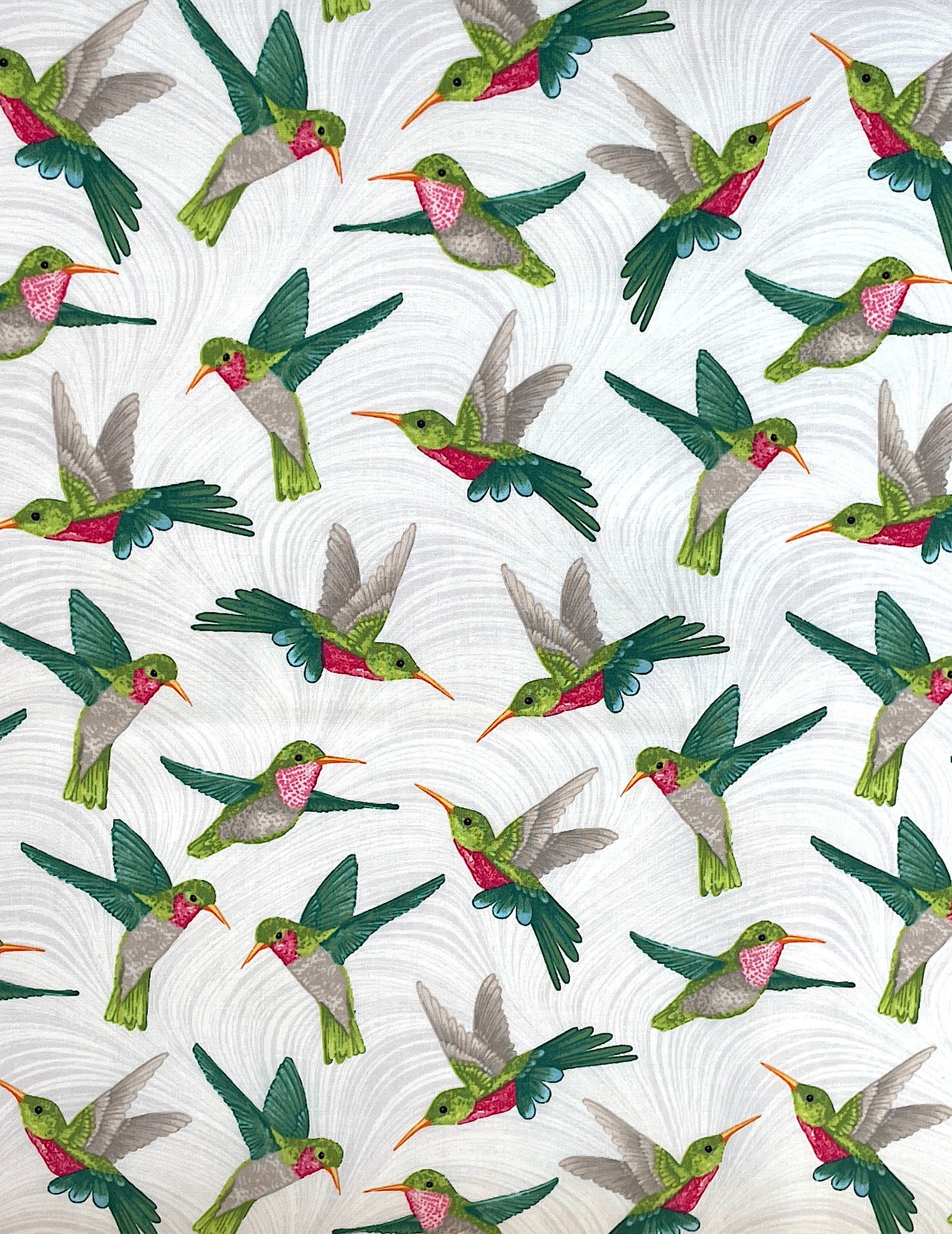 White cotton fabric covered with hummingbirds that are  green, pink and grey.
