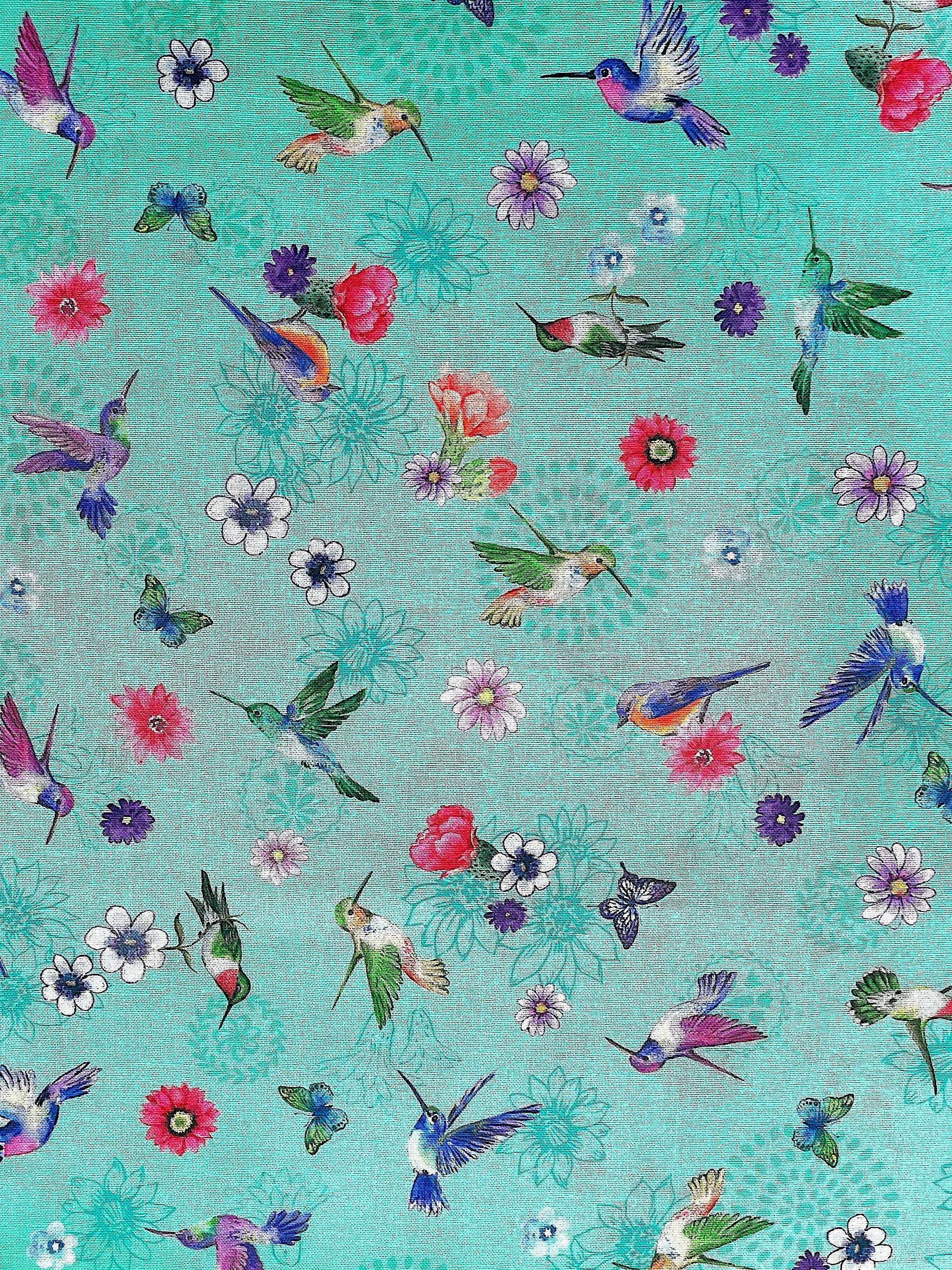 Aqua cotton fabric is covered with hummingbirds, flowers and hummingbirds.