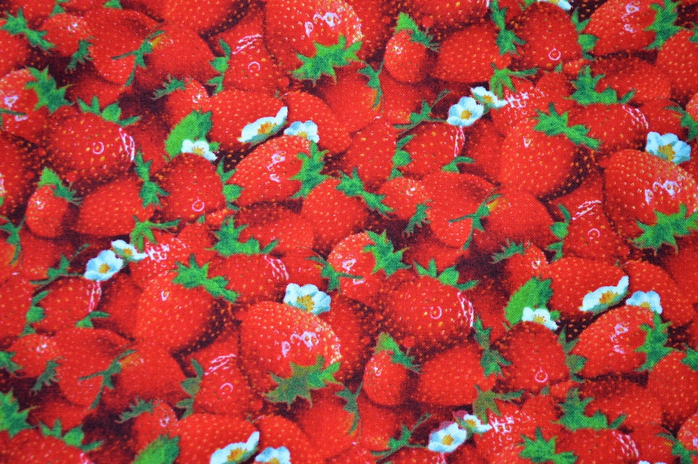 Strawberries are scattered all over this fabric.