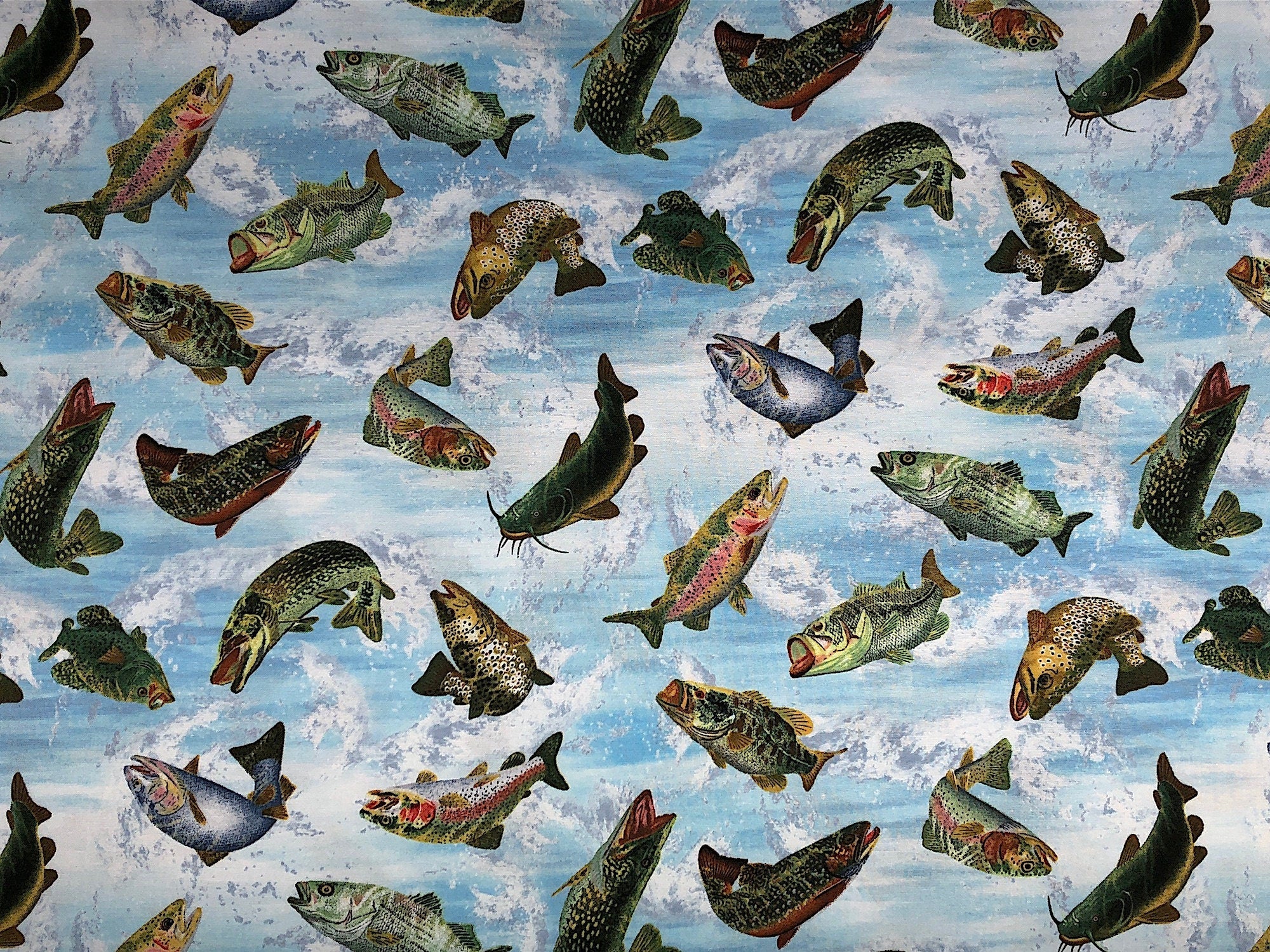 This blue fabric is covered with fish. The fish look like they are jumping in and out of the water.