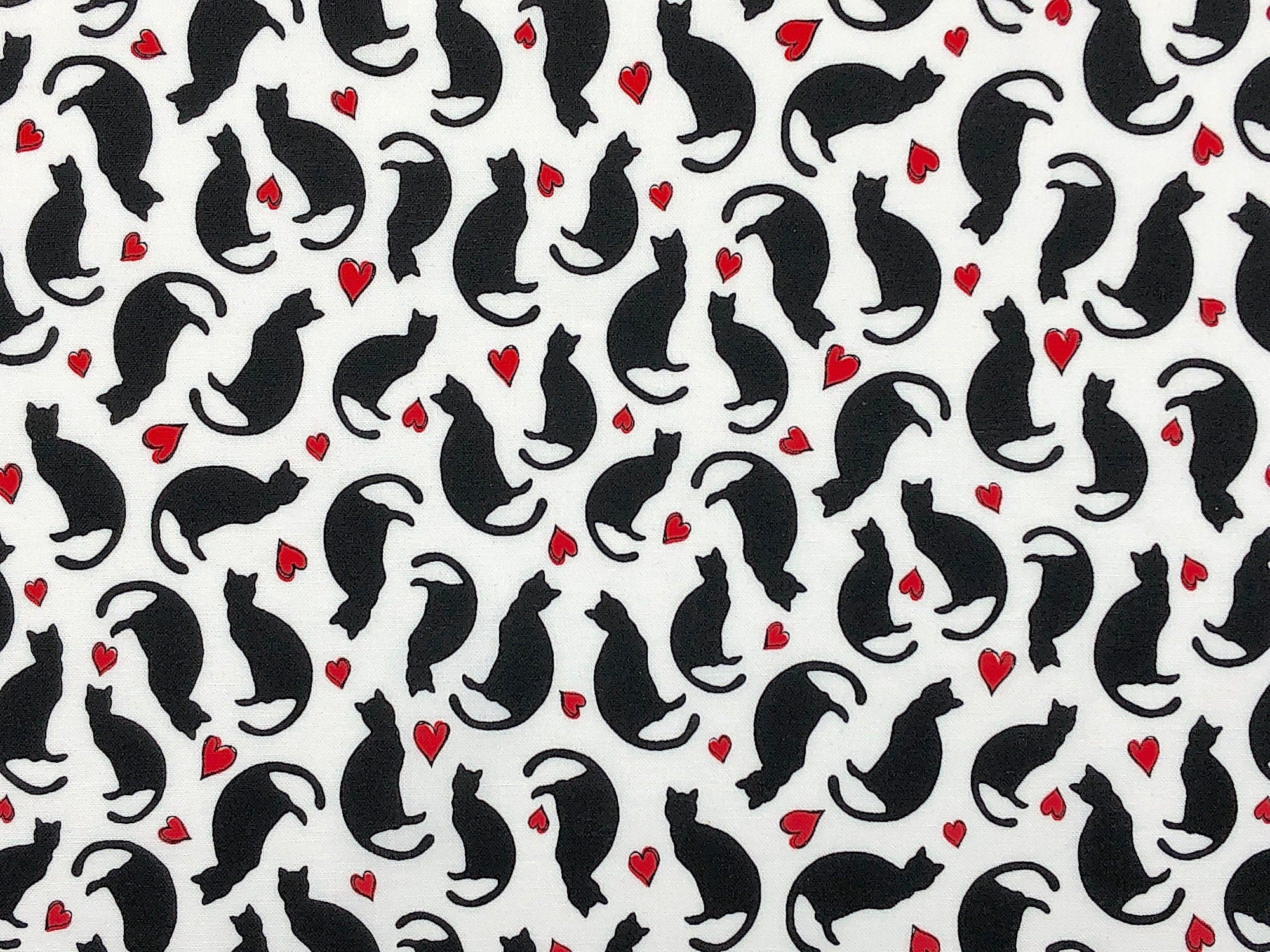 This fabric is called Parisian Cats with Hearts. This white fabric is covered with black cats and red hearts.