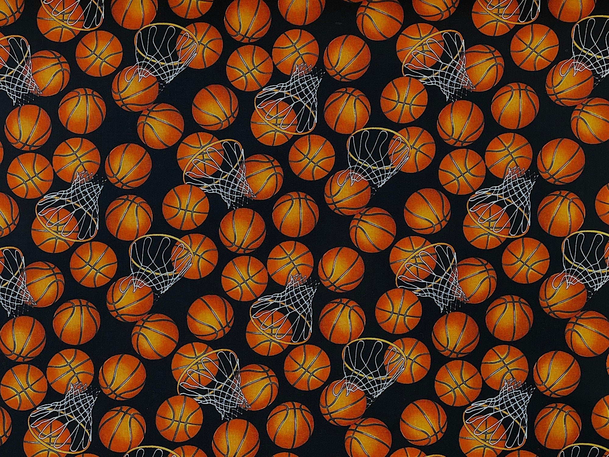 This black fabric is covered with orange basketballs and hoops.