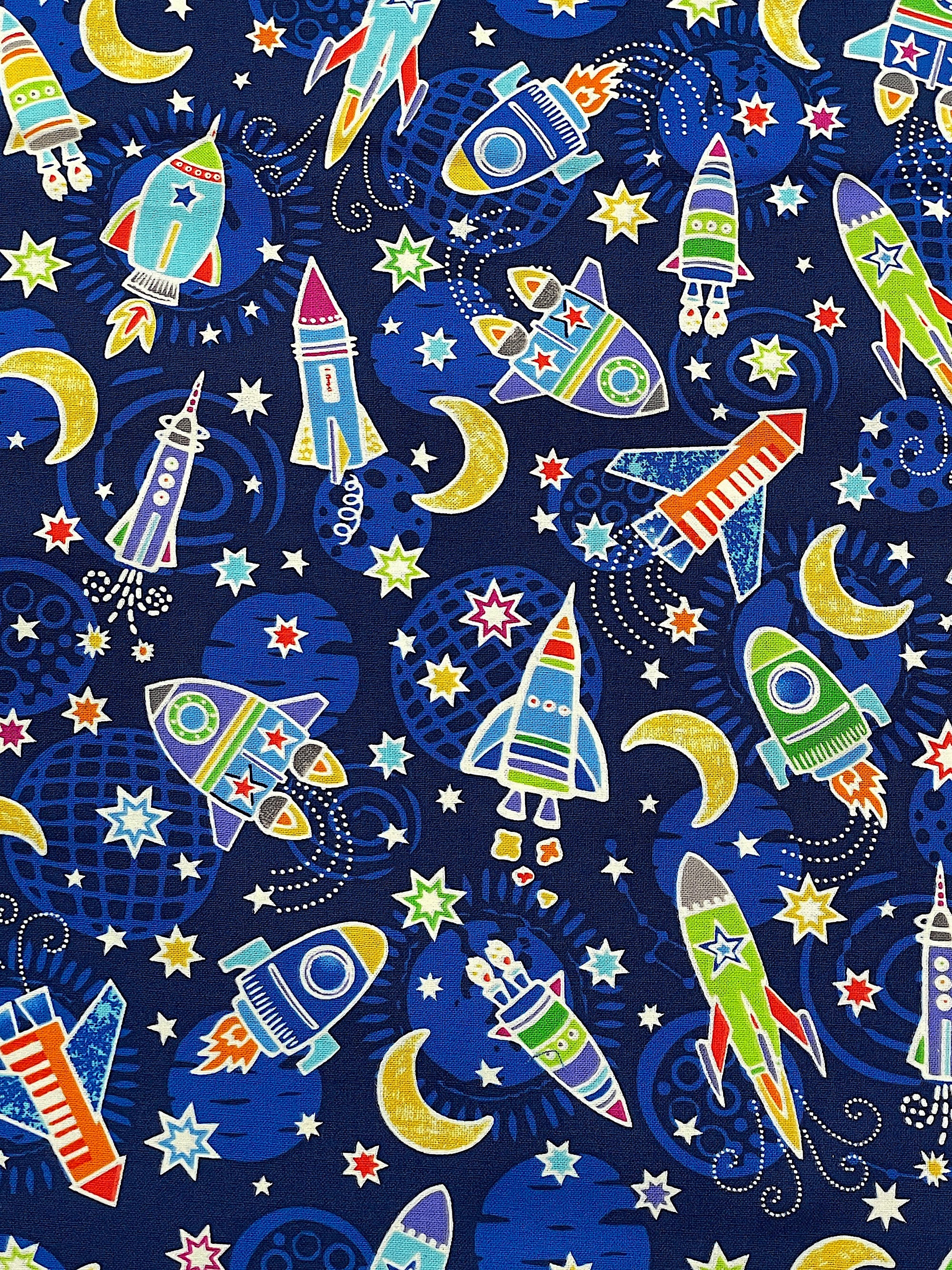 This fabric is part of the Lift Off collection by Kanvas Studio. This blue fabric is covered with space rockets and stars.