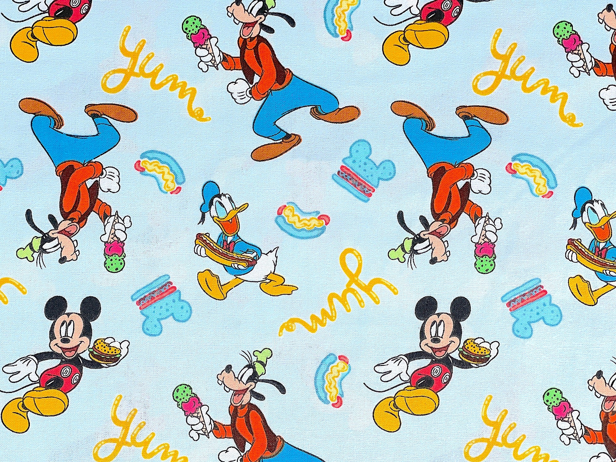 Light blue cotton fabric covered with Mickey Mouse, Donald Duck and Goofy.