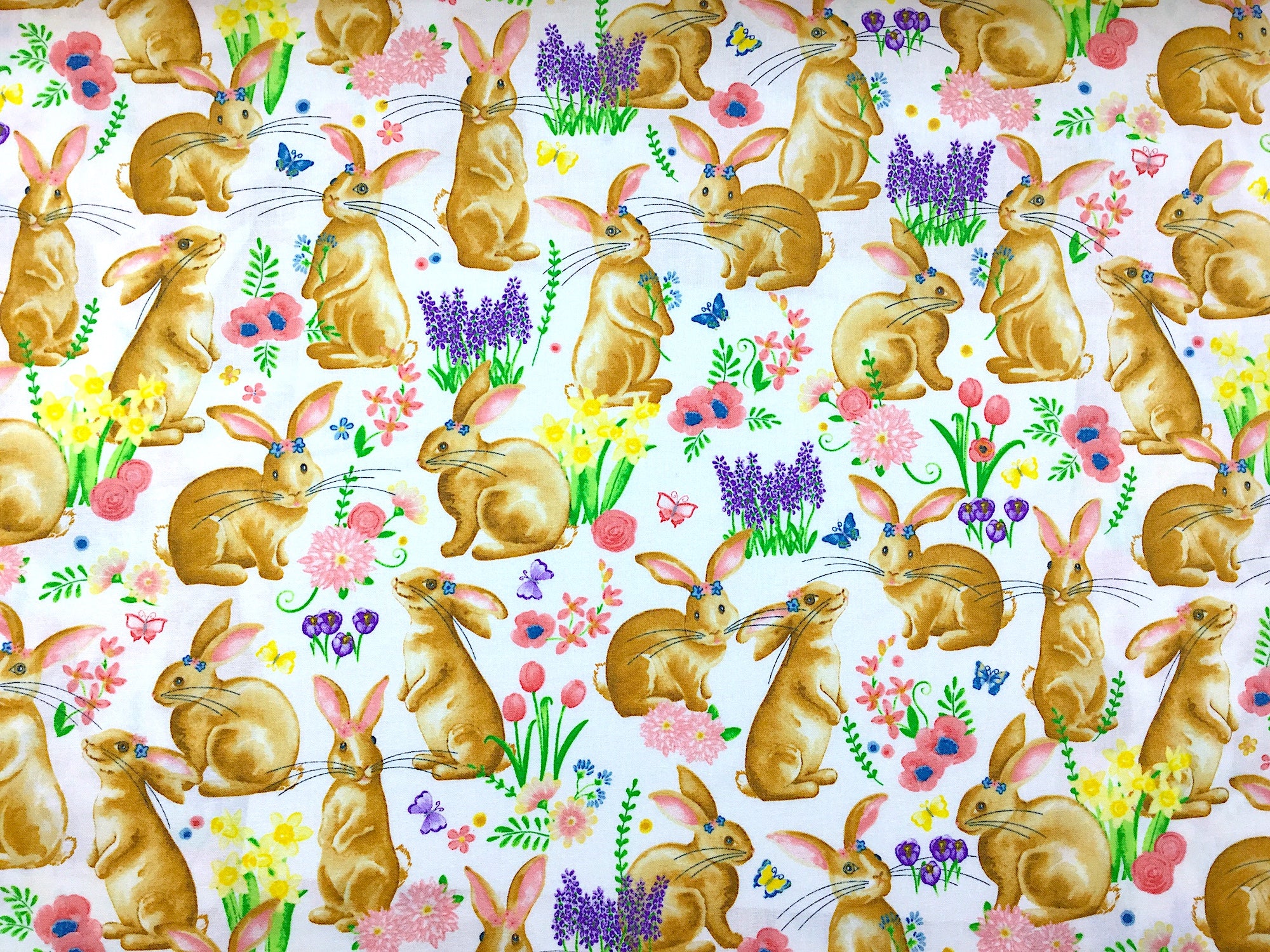 Cotton fabric covered with bunnies, and flowers.
