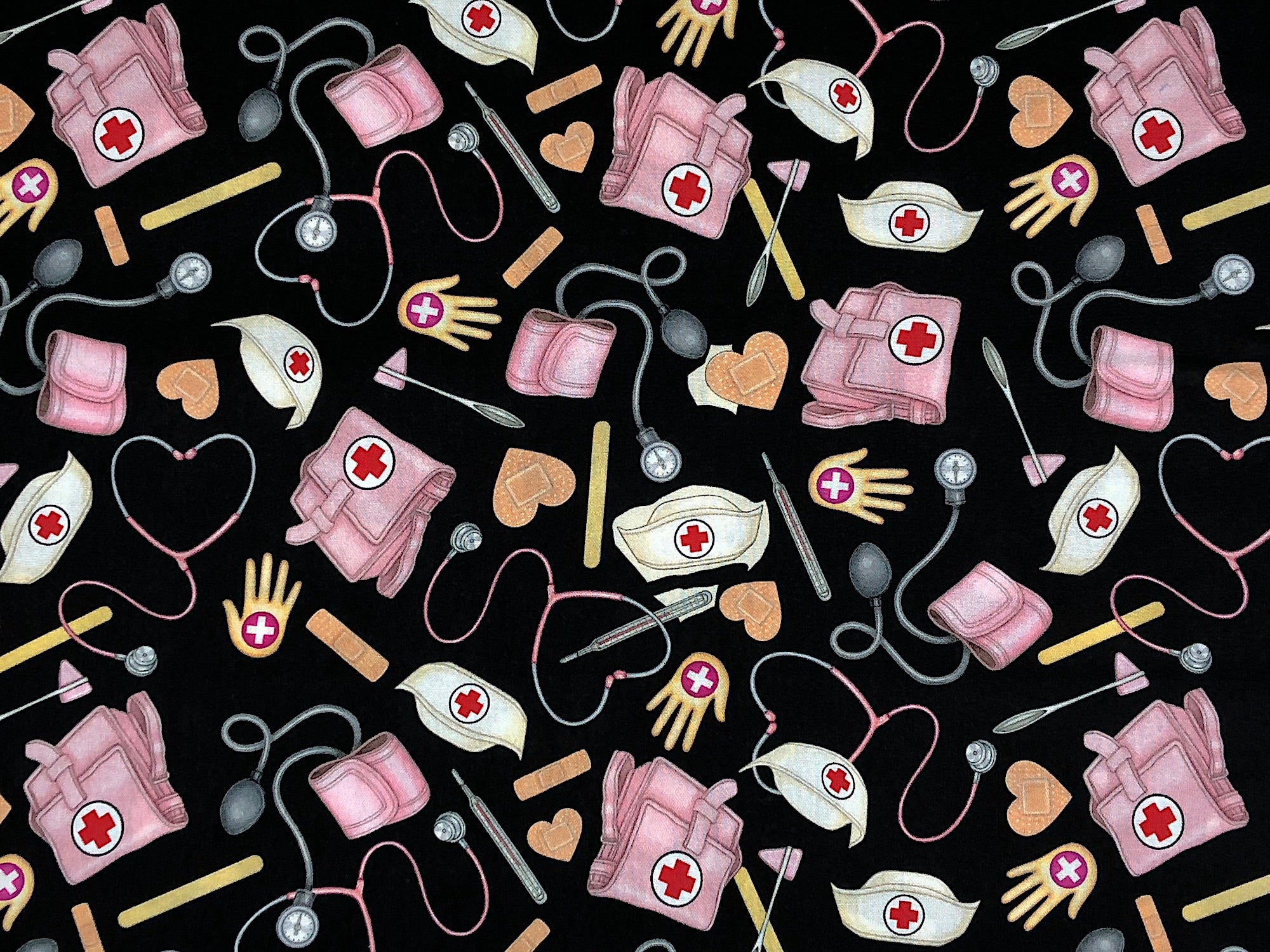 Black cotton fabric covered with nurse hats, bags, stethoscopes and more.