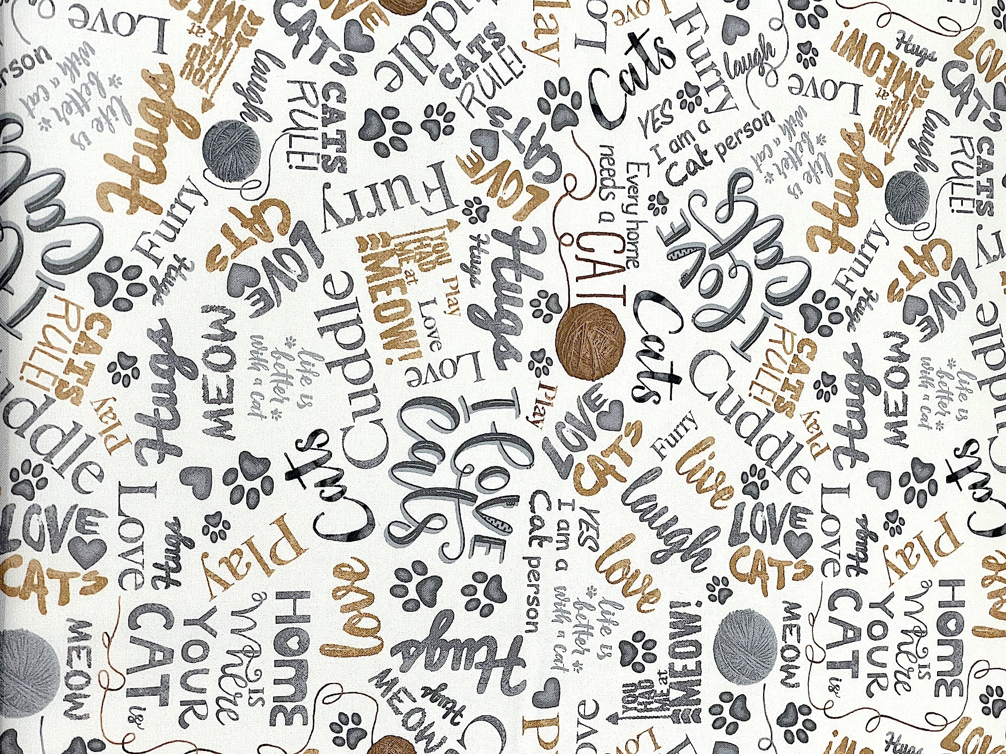 This cream colored cotton fabric is covered with balls of yarn and cat sayings.&nbsp; Some of the cat sayings are cuddle, meow, cats rule, home is where your cat is, meow, laugh and more.