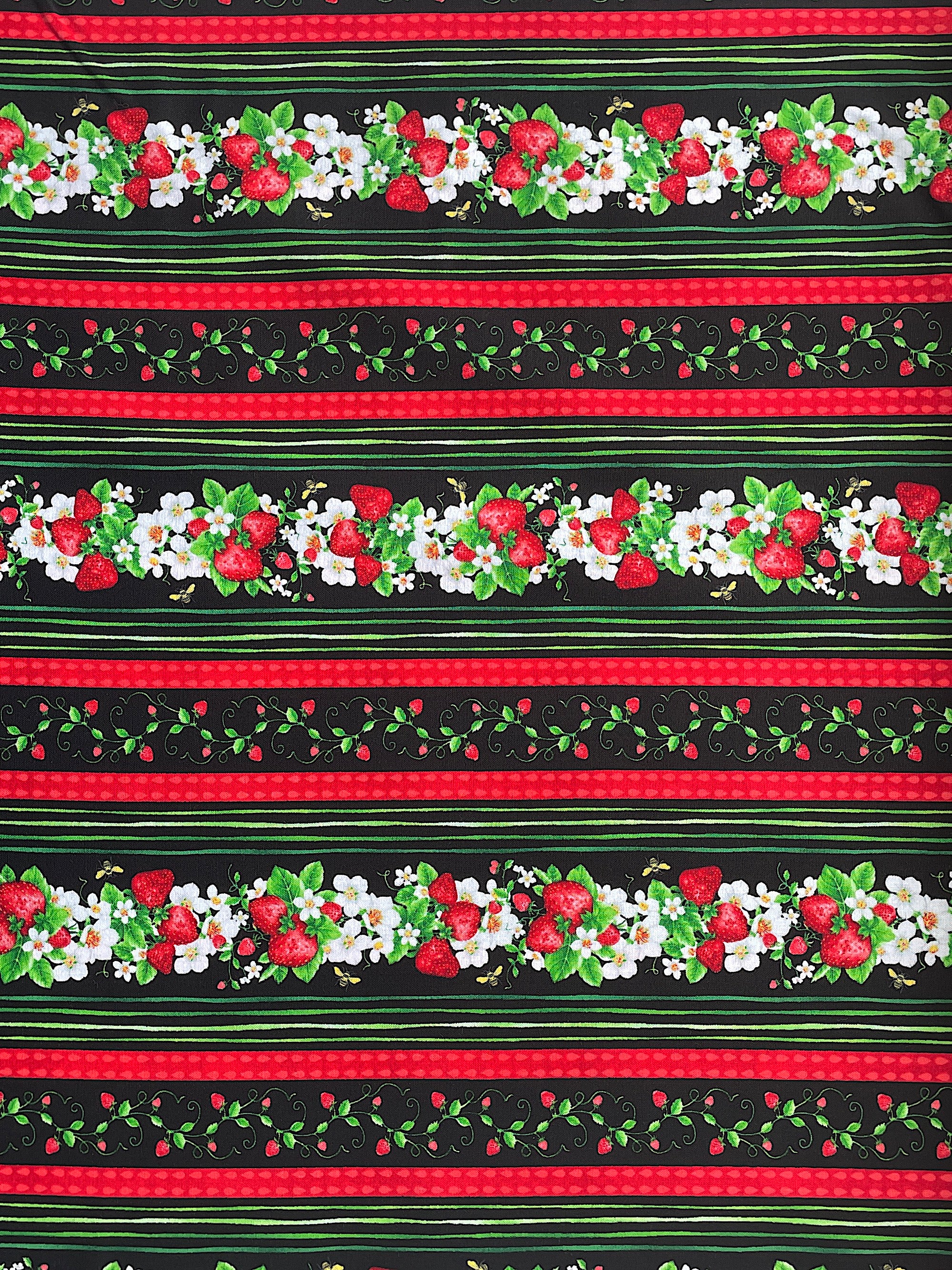 Black cotton fabric covered with rows of  strawberries, flowers and leaves.  