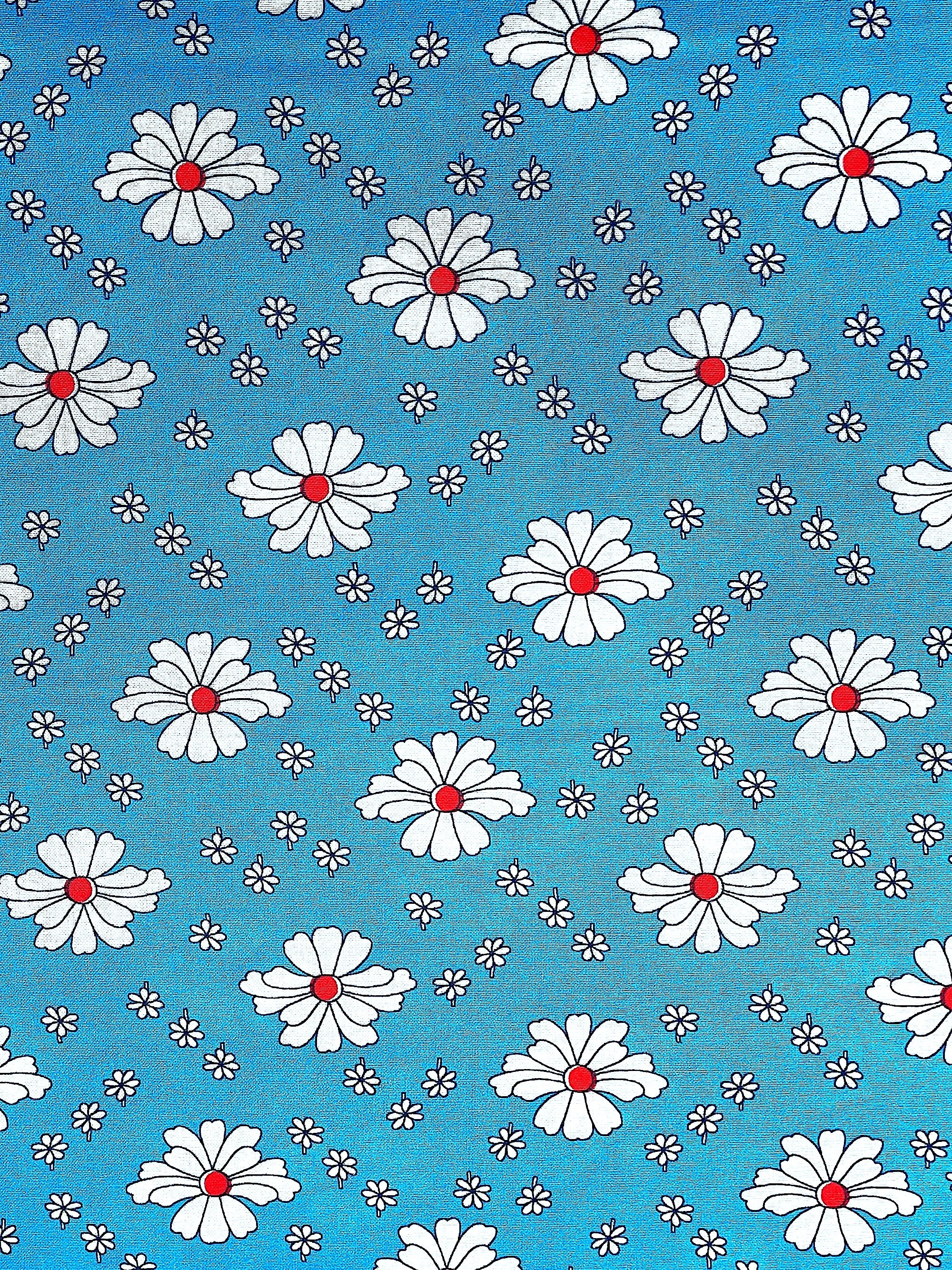 Blue cotton fabric covered with white flowers with red centers.