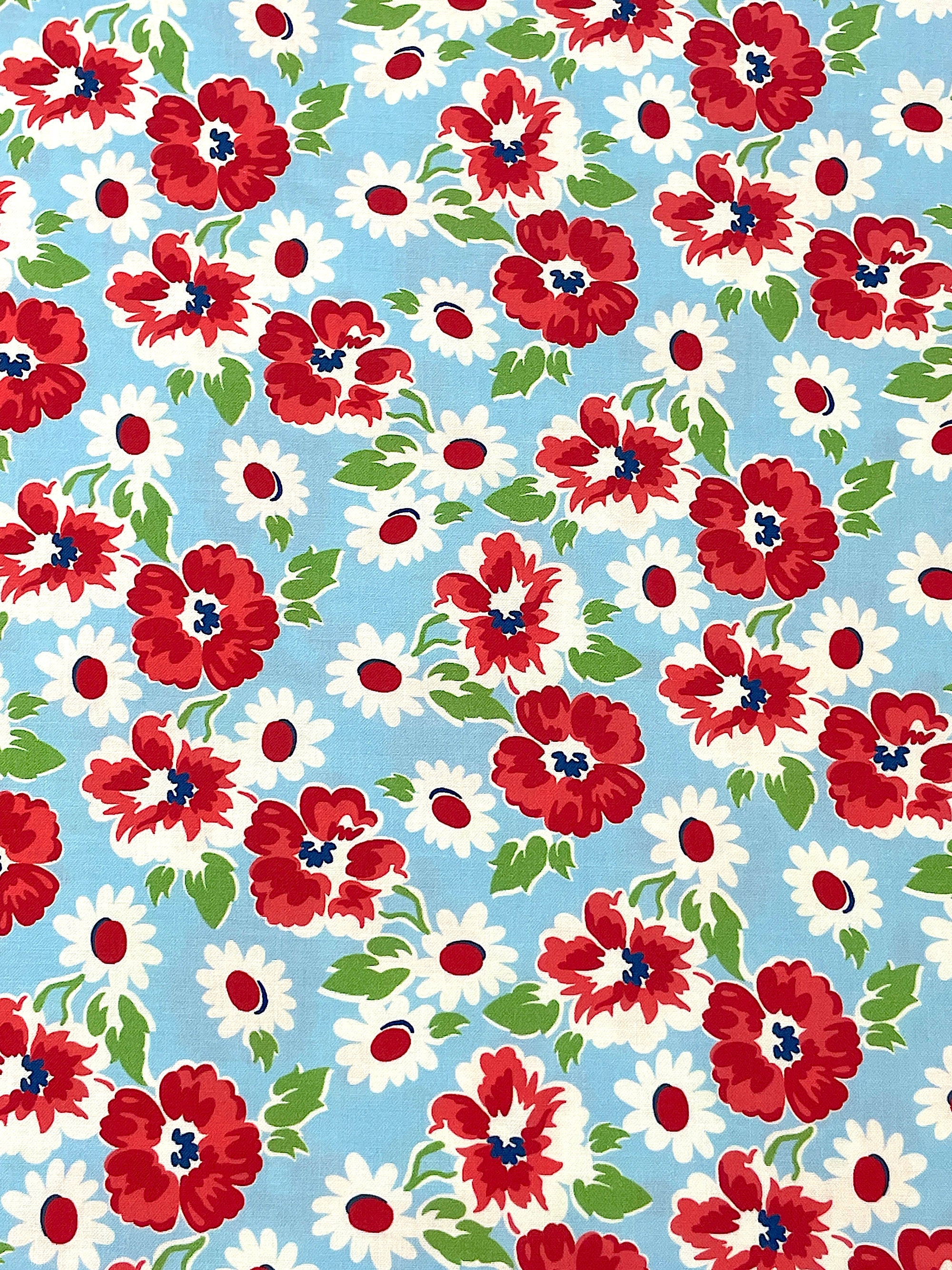 Blue cotton fabric covered with red and white flowers and green leaves.
