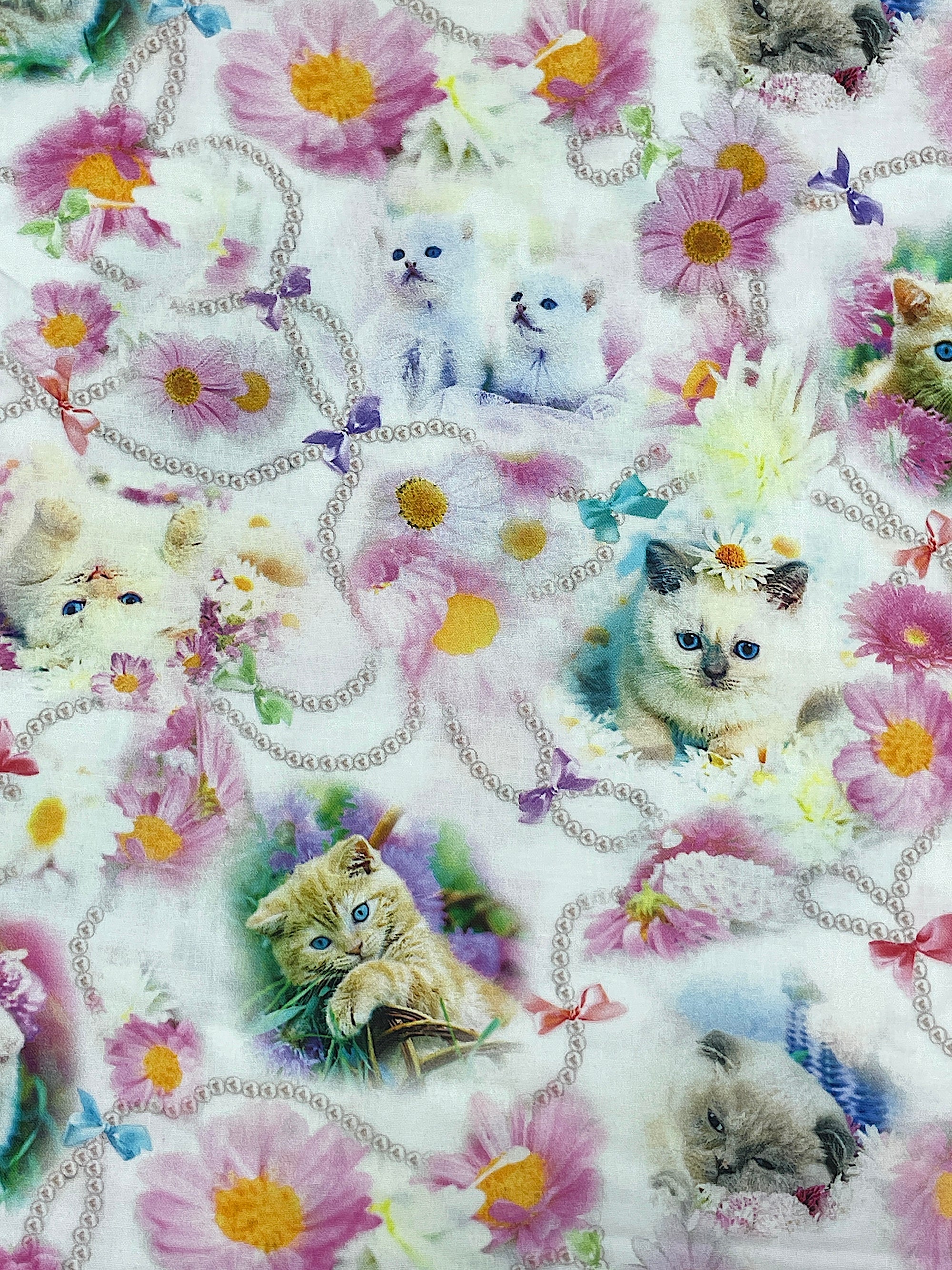Kittens surrounded with flowers and beads.