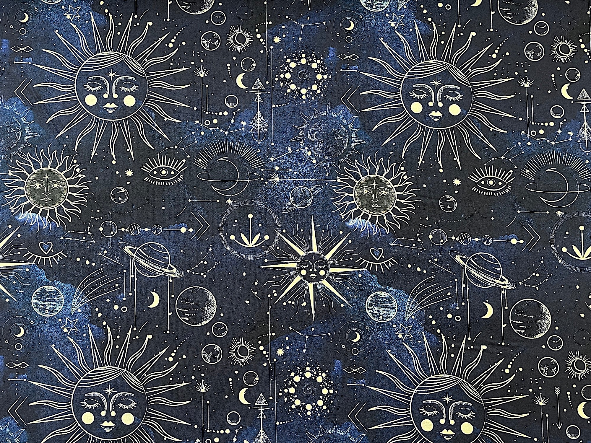 This dark blue cotton fabric is covered with the sun, moon, planets and more.