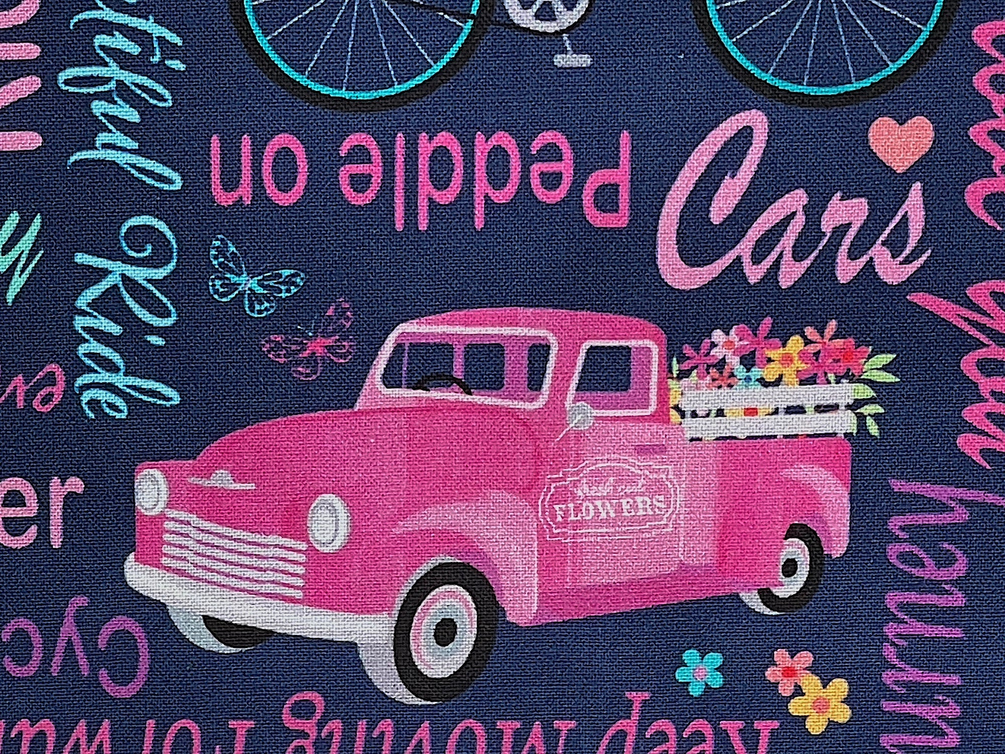 Close up of a pink truck filled with flowers.
