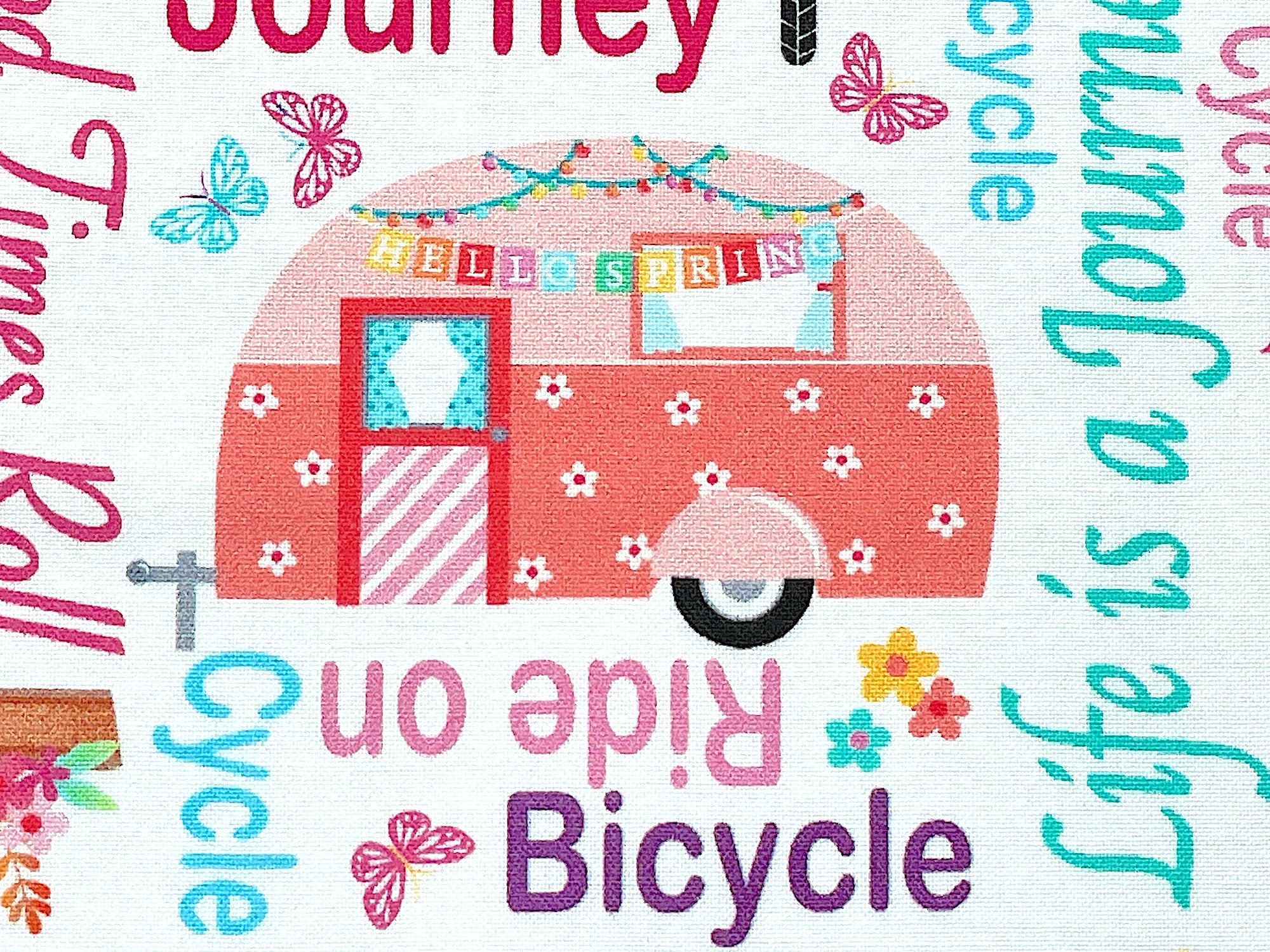 Close up of an travel trailer with a hello spring banner on it.