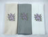 Three kitchen towels with floral embroidery on a white background