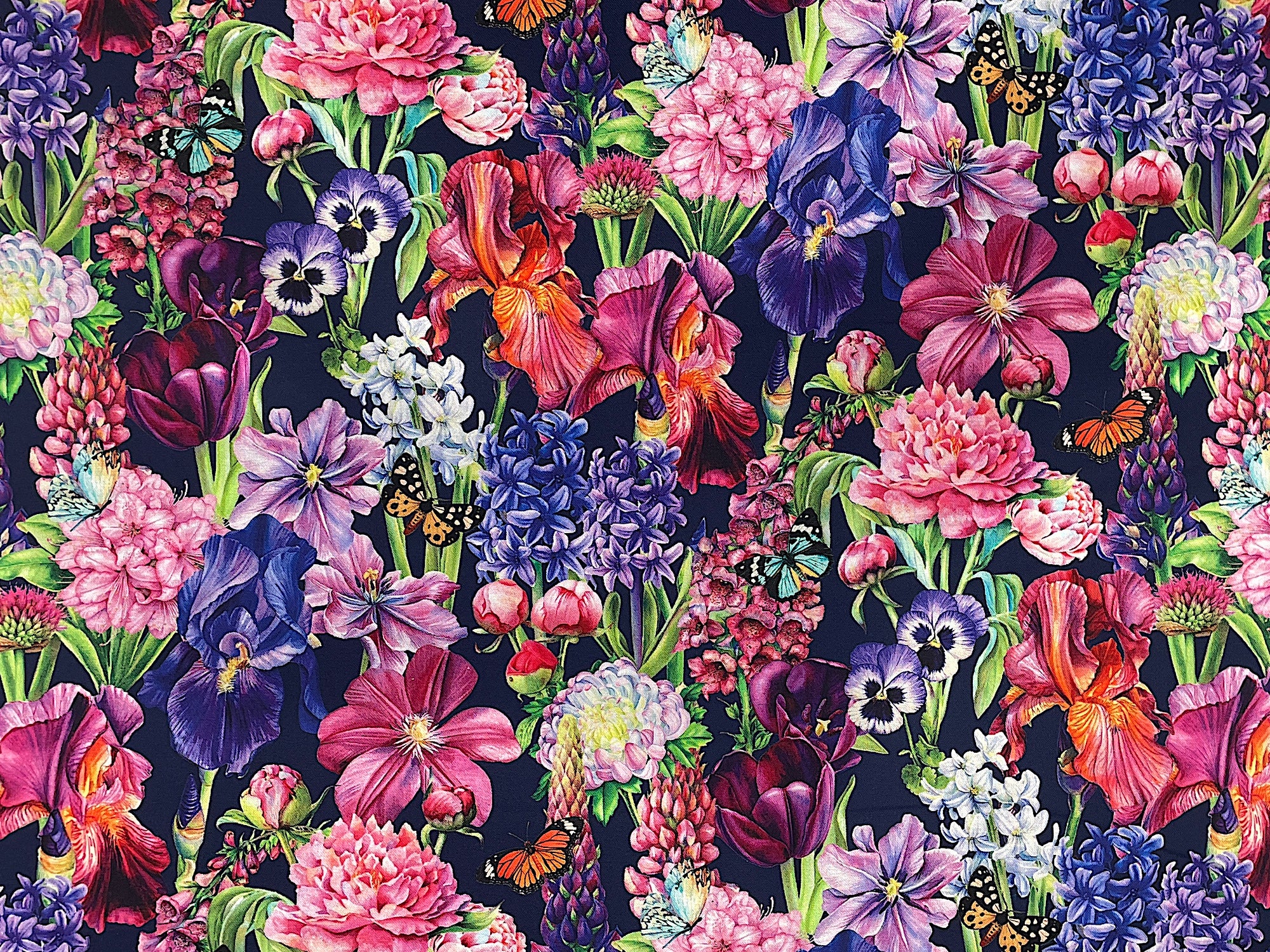 From Northcott Fabrics this dark blue fabric is covered with pretty flowers such as iris, pansies clematis, peonies, lupines, and hyacinth. You will also see yellow, orange and white butterflies throughout.&nbsp;