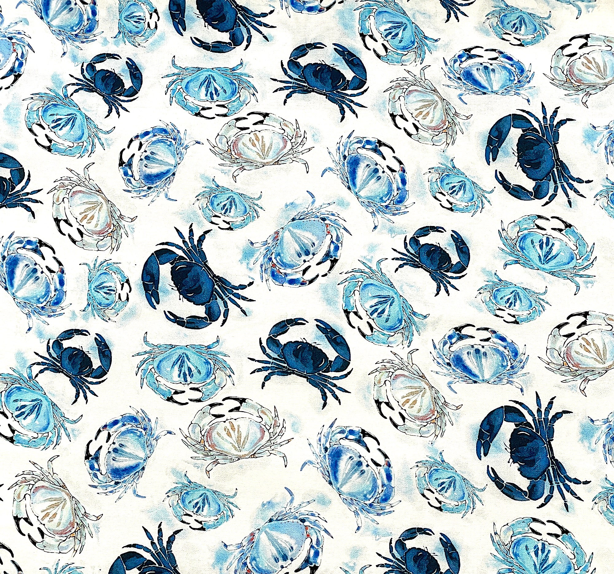 White cotton fabric covered with crabs in various shades of blue