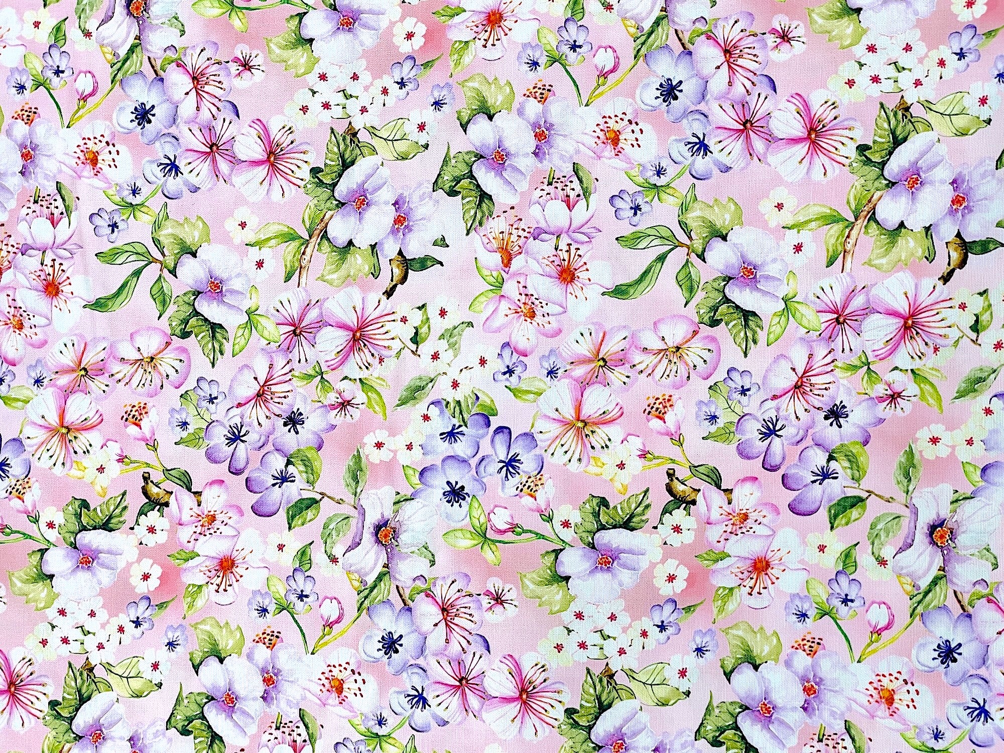 Light pink cotton fabric covered with pink and purple flowers.
