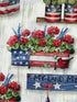 Close up of a flag planter box filled with red geraniums.