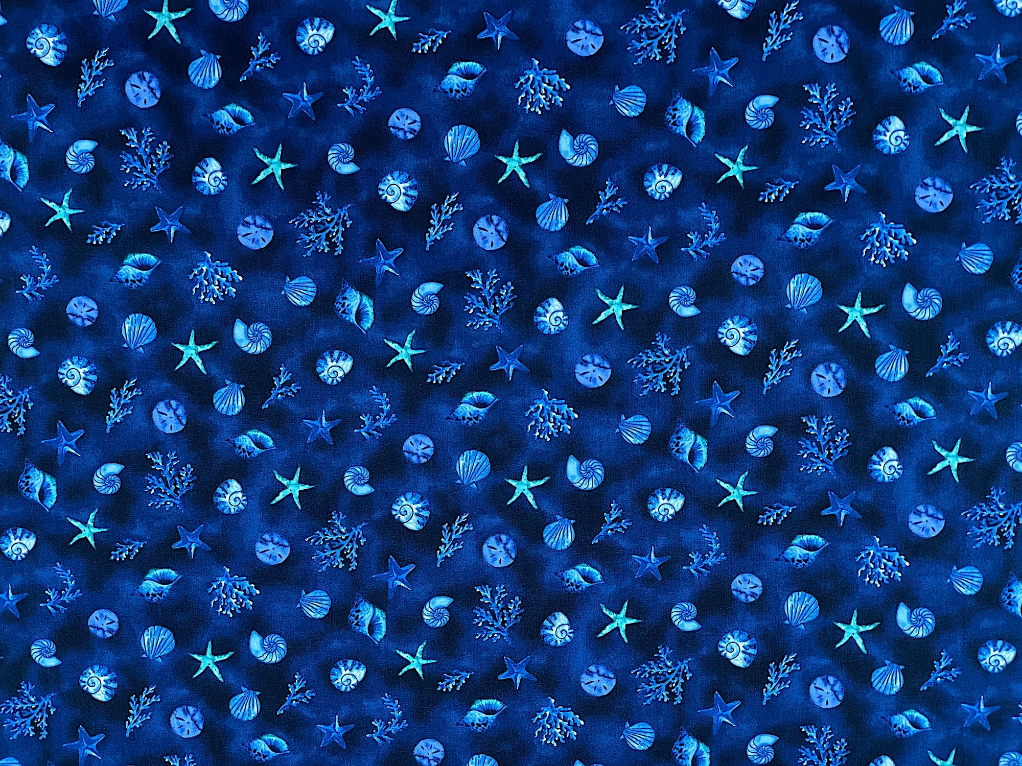 This blue cotton fabric is part of The Sea is Calling collection.&nbsp; This fabric is covered with, starfish, coral, sea shells and more