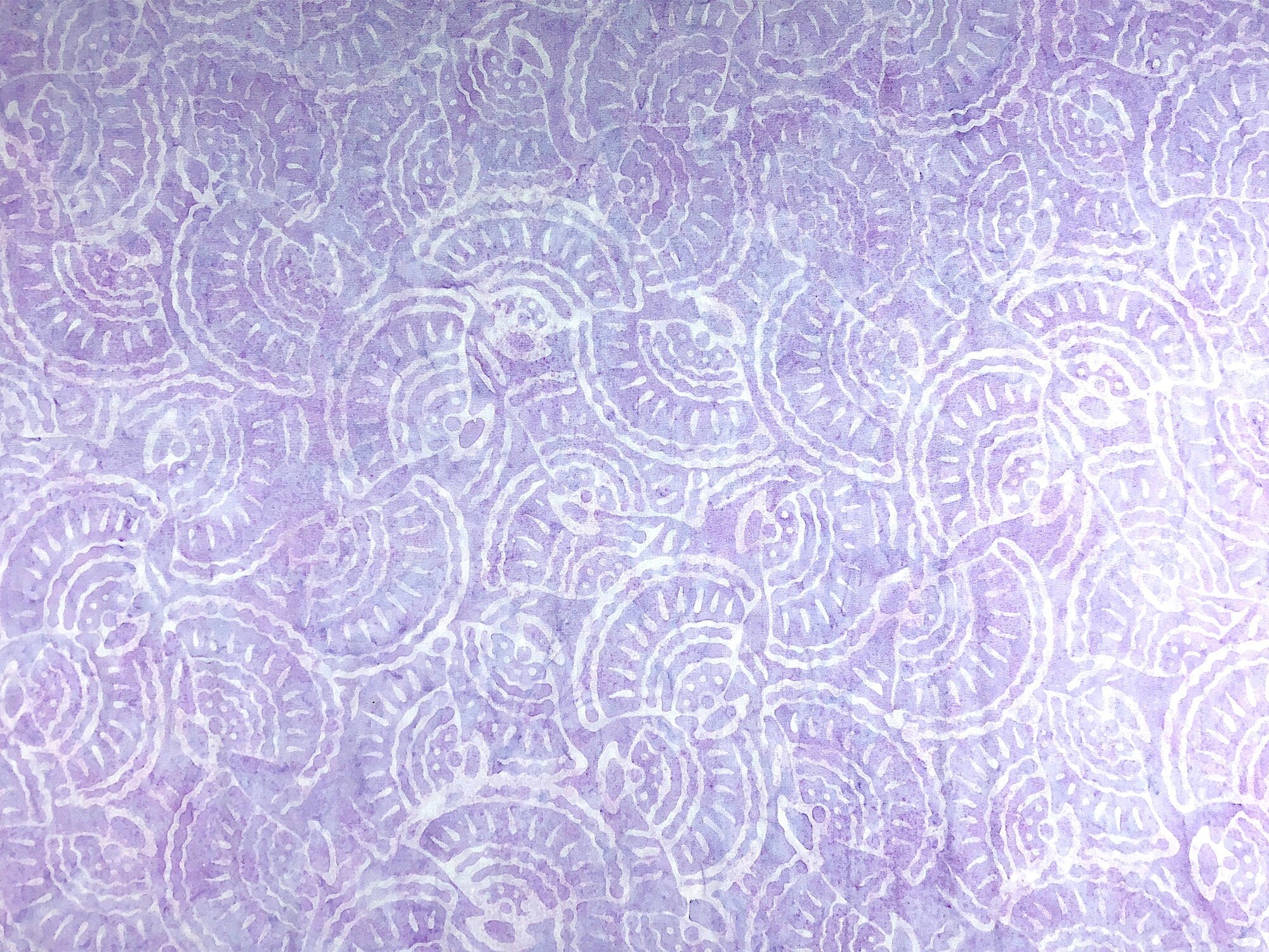 This lilac fabric is covered with seashells of a lighter lilac color.