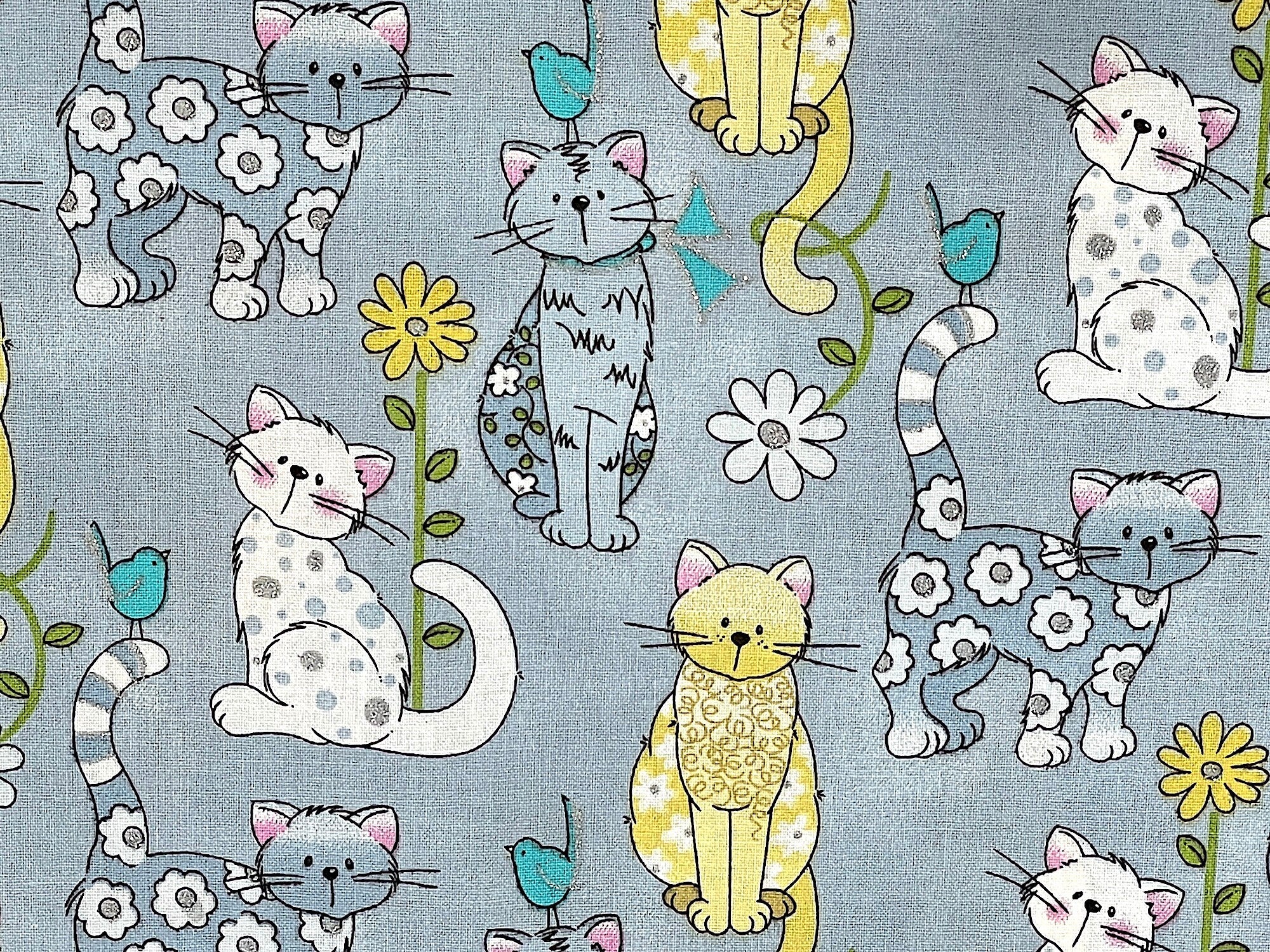 Close up of grey, white and yellow cats and flowers.