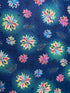 This Enchanted Floral fabric is covered with colorful flowers which are a combination of pink, purple, lavender, pink and green. The background has two colors blue and a light green which is around some of the flowers.