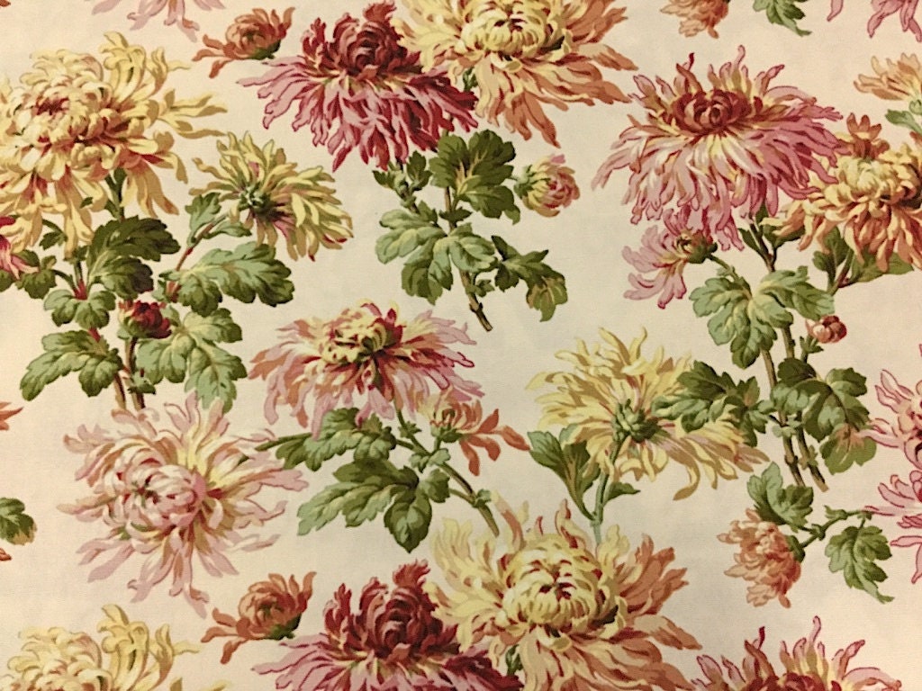 This cotton canvas weight fabric has mums on a cream background. The mums are different colors and sizes.