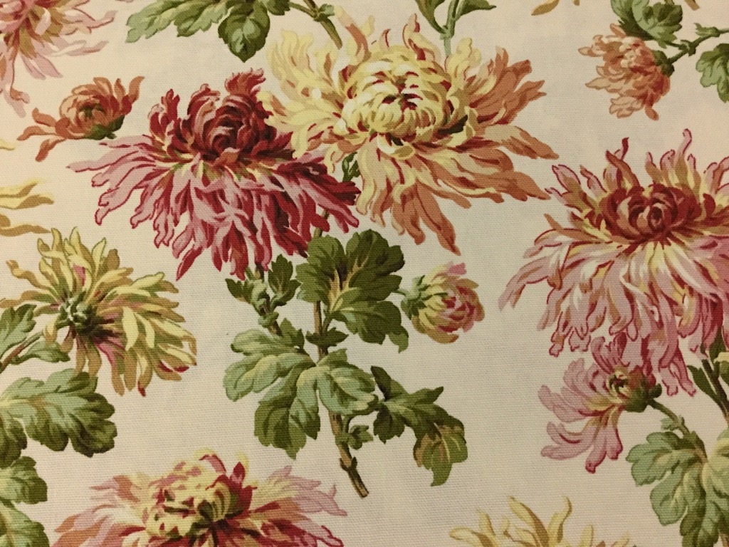 This cotton canvas weight fabric has mums on a cream background. The mums are different colors and sizes.