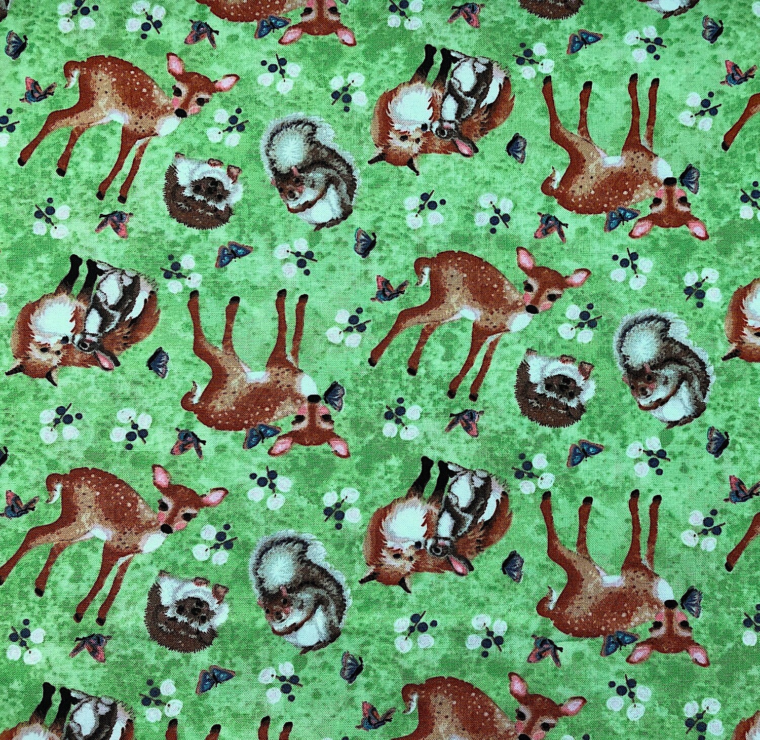 This green fabric is covered with young forest animals. There are deer, fox, and other young animals.