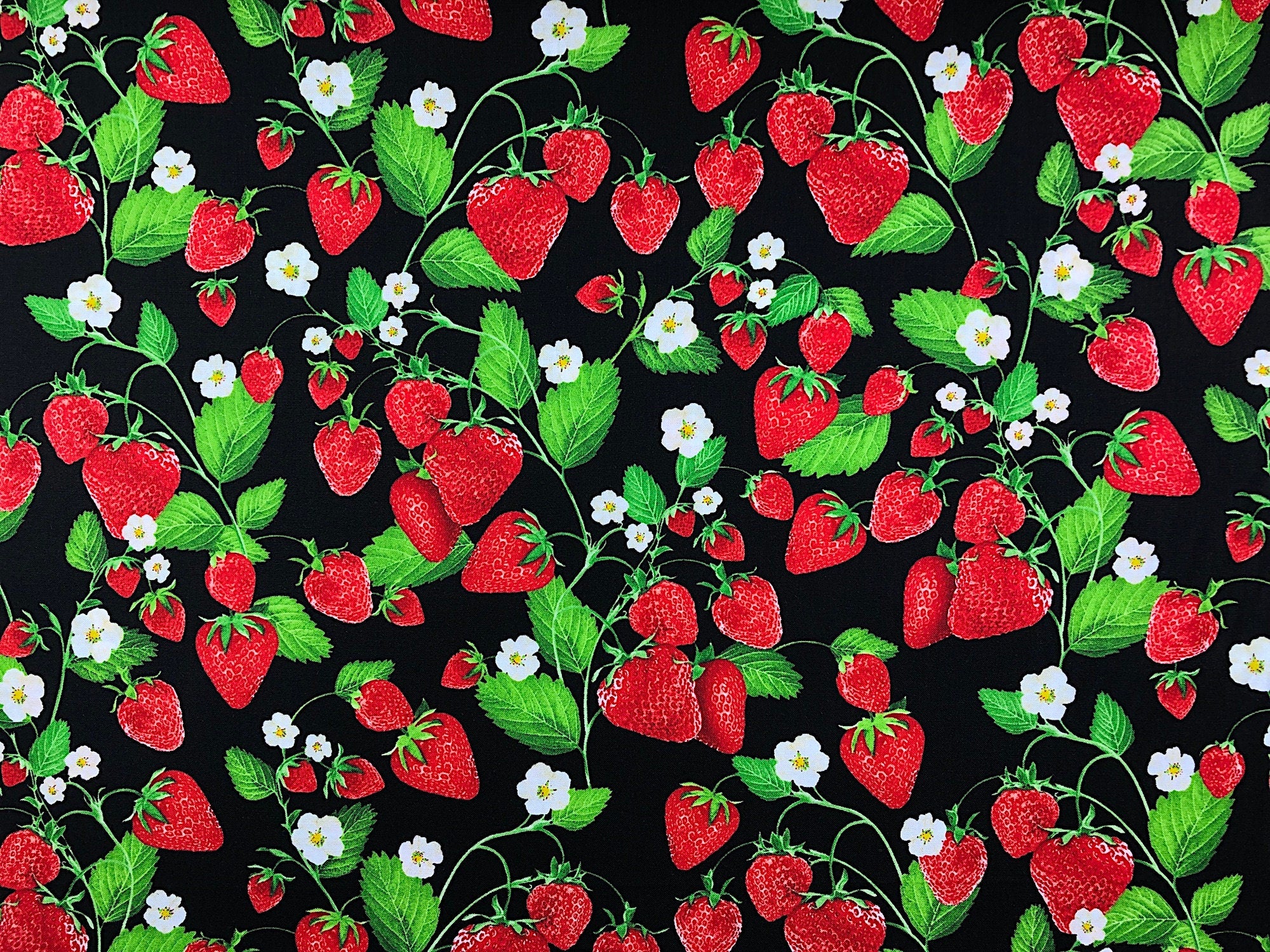 This Black fabric is covered with strawberries and flowers on the vine. The vines are scattered throughout the entire fabric pattern