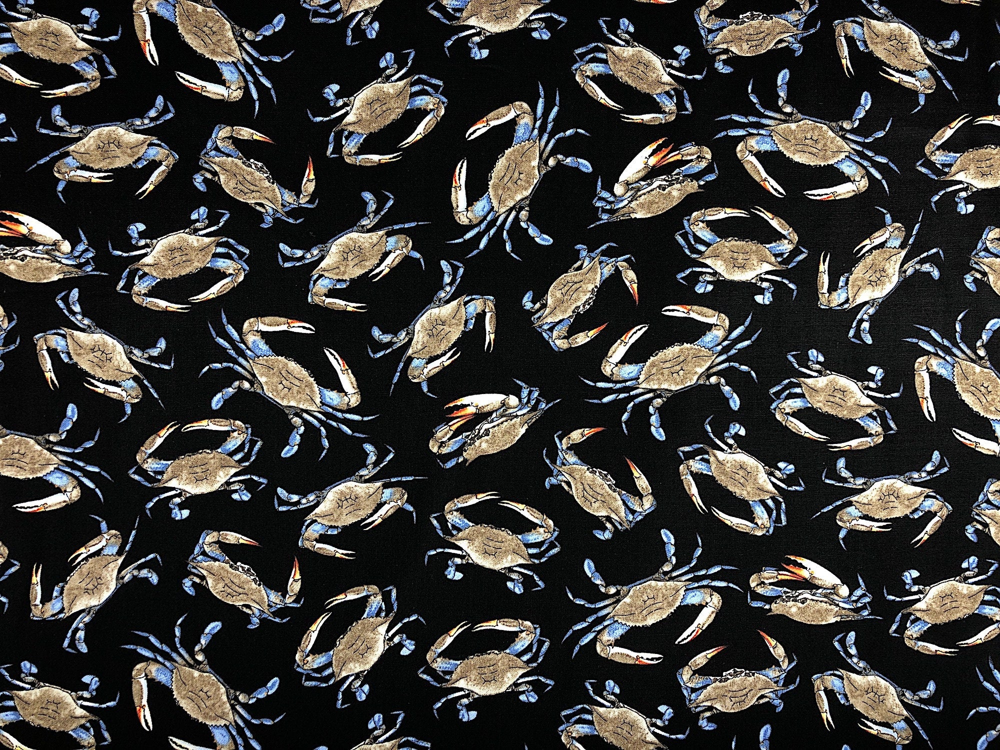 This black fabric by Timeless Treasures is covered with Crabs that are arranged randomly throughout the fabric pattern.