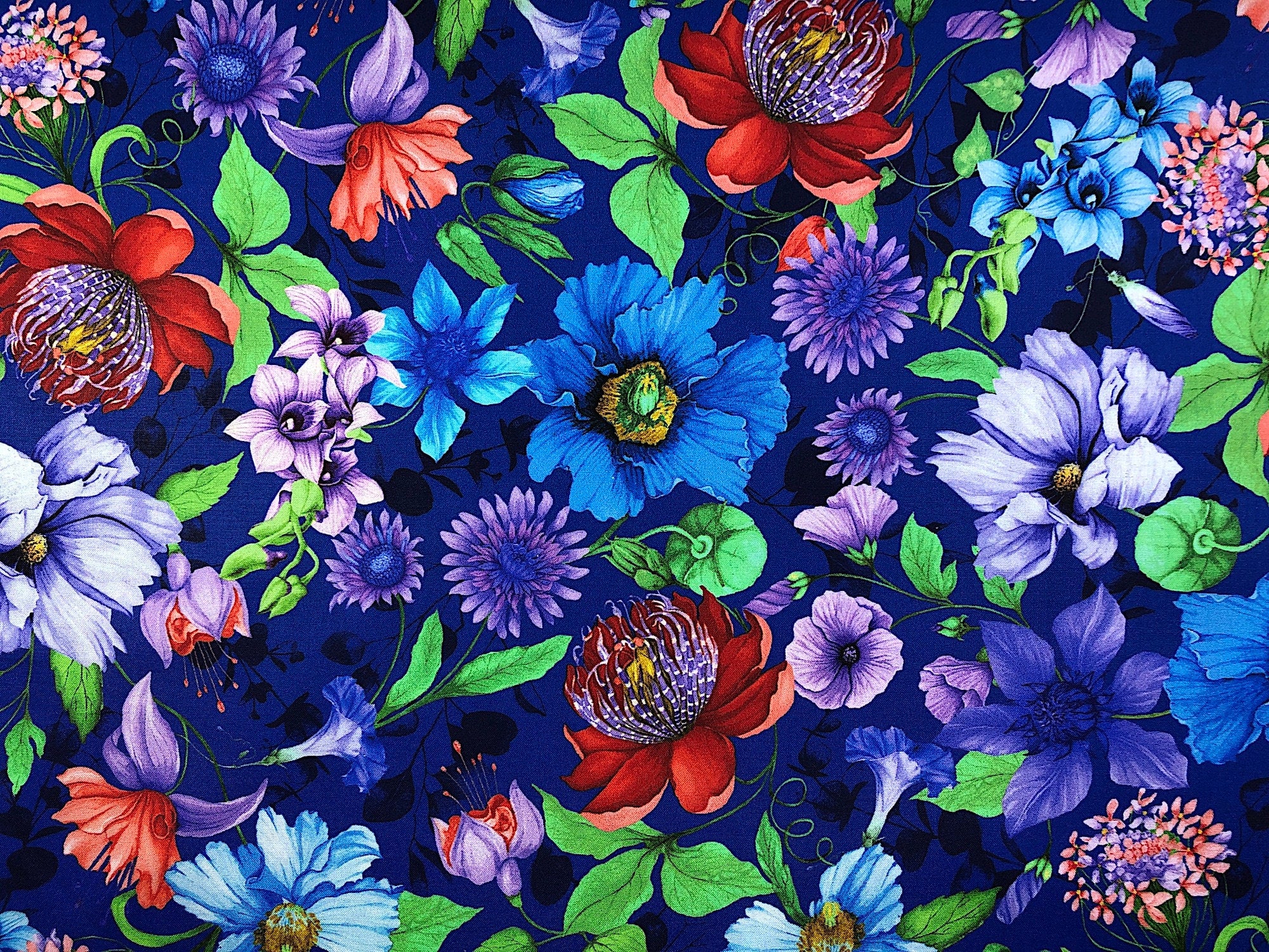 This Blue fabric is covered with flowers of all types that are placed randomly throughout the pattern.