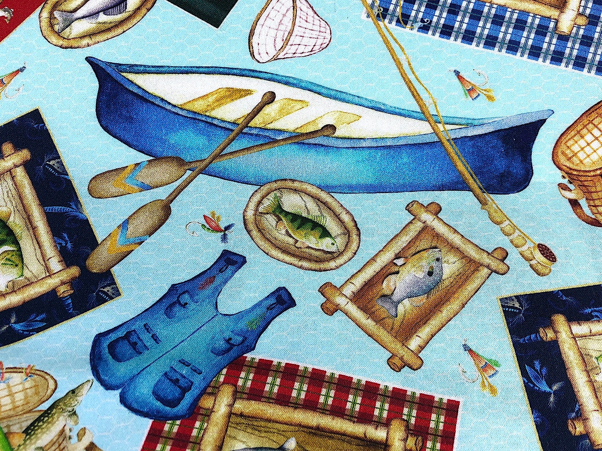 This fabric is part of the Keep it Reel collection and has fish, boats, oars, nets and more on a blue netting background.
