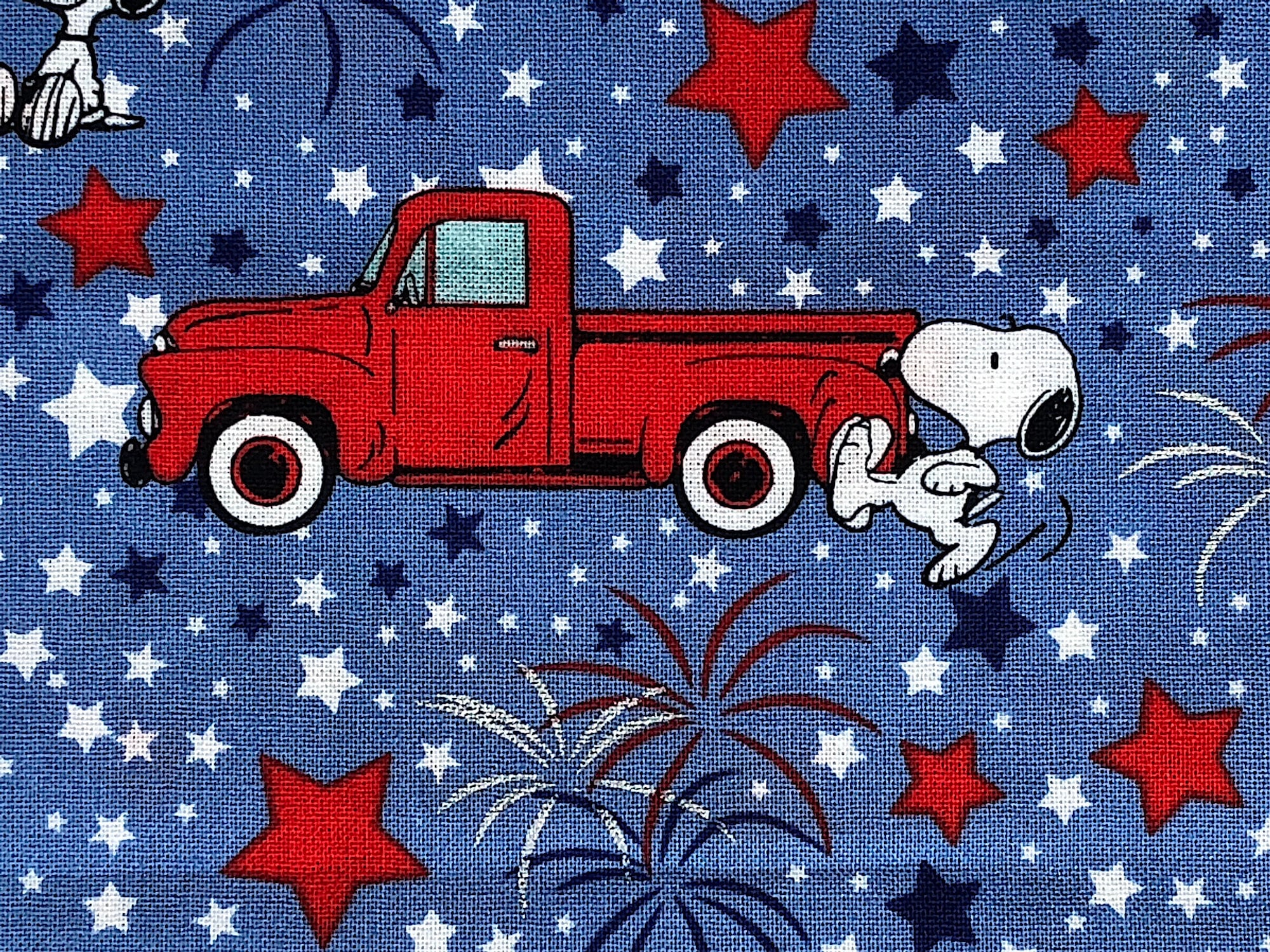 Close up of a red truck, snoopy , stars and fireworks.