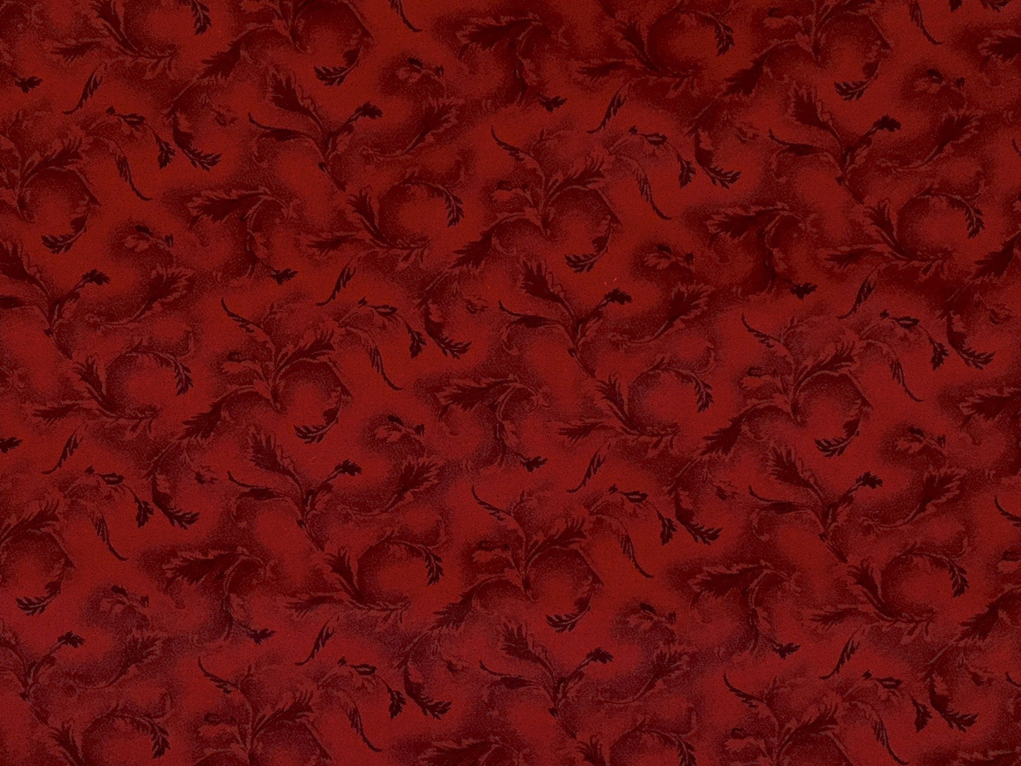 Red cotton fabric covered with leaves.