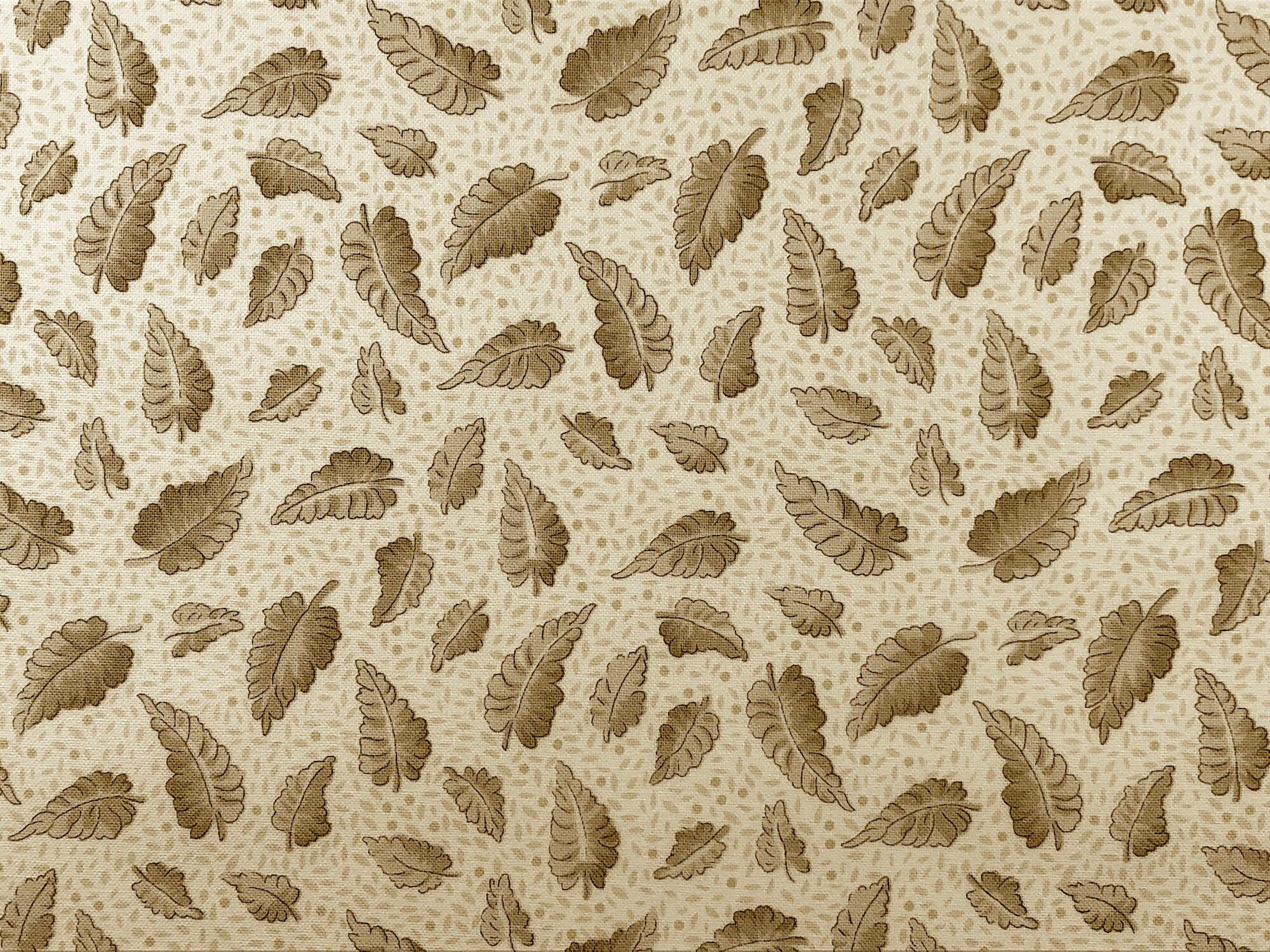 This fabric is part of the Village Garden Collection and has leaves in shades of brown on a cream colored background.