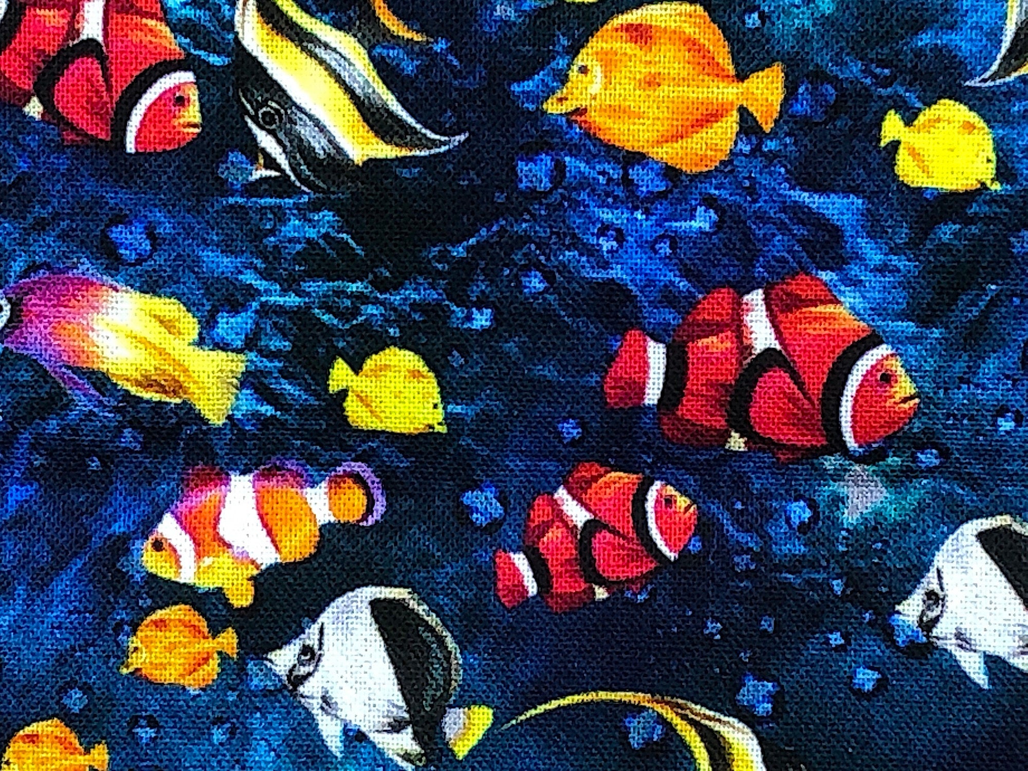 This fabric is part of the Reef Collection and is covered with angel fish, clown fish, yellow tang fish, and more on a water background.
