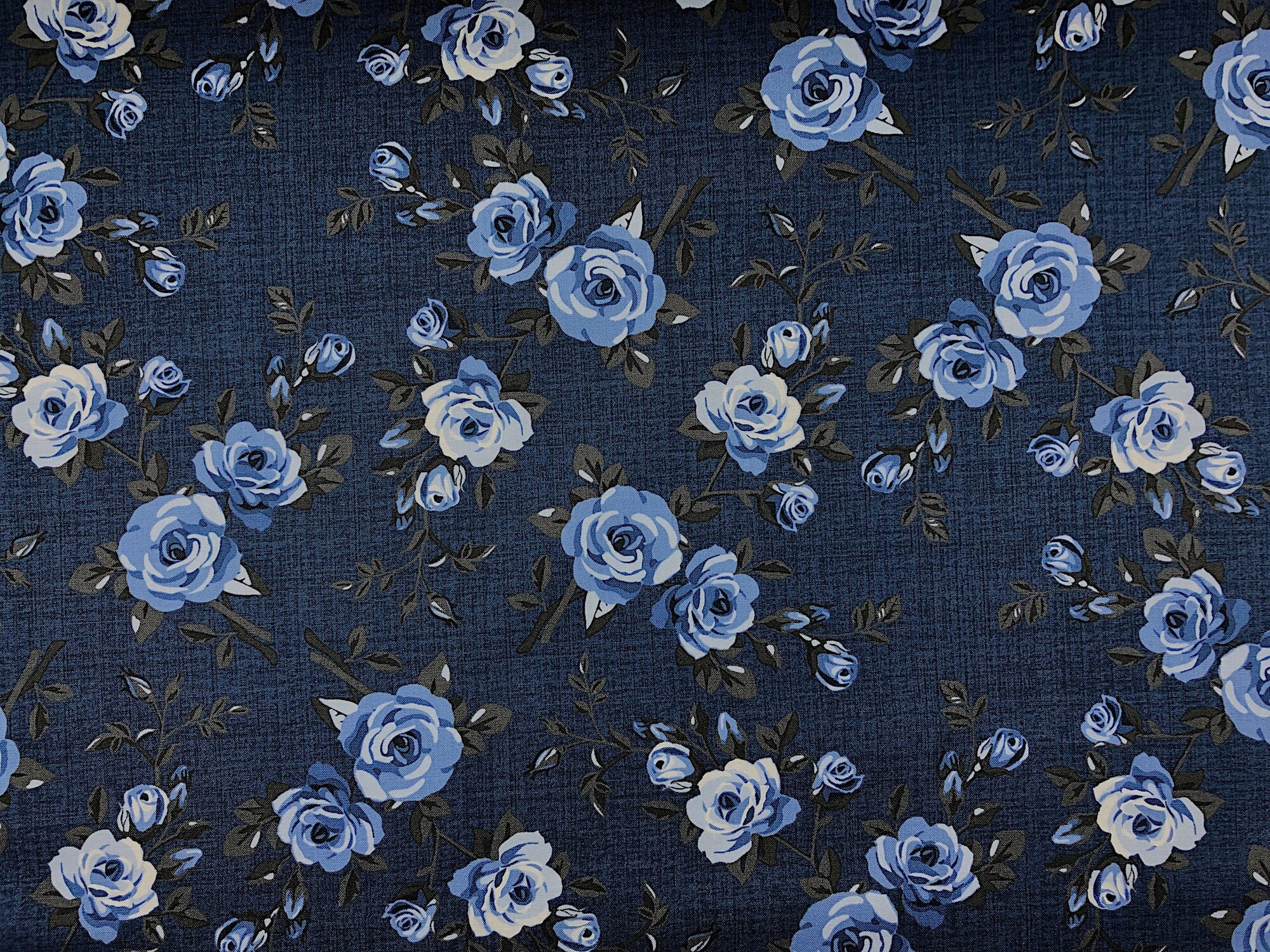 This fabric is part of the Elegant Blooms Collection and is covered with blue roses on a dark blue background.