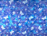 This fabric is covered with different sized white butterflies. The background is a mixture of various shades of blue and lavender.