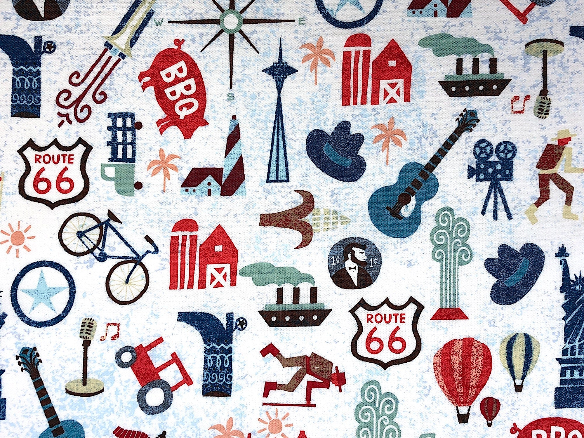 This fabric is called Across the USA and is covered with guitars, skiers, the statue of liberty, hot air balloons, cars, bicycles a BBQ pig and more.
