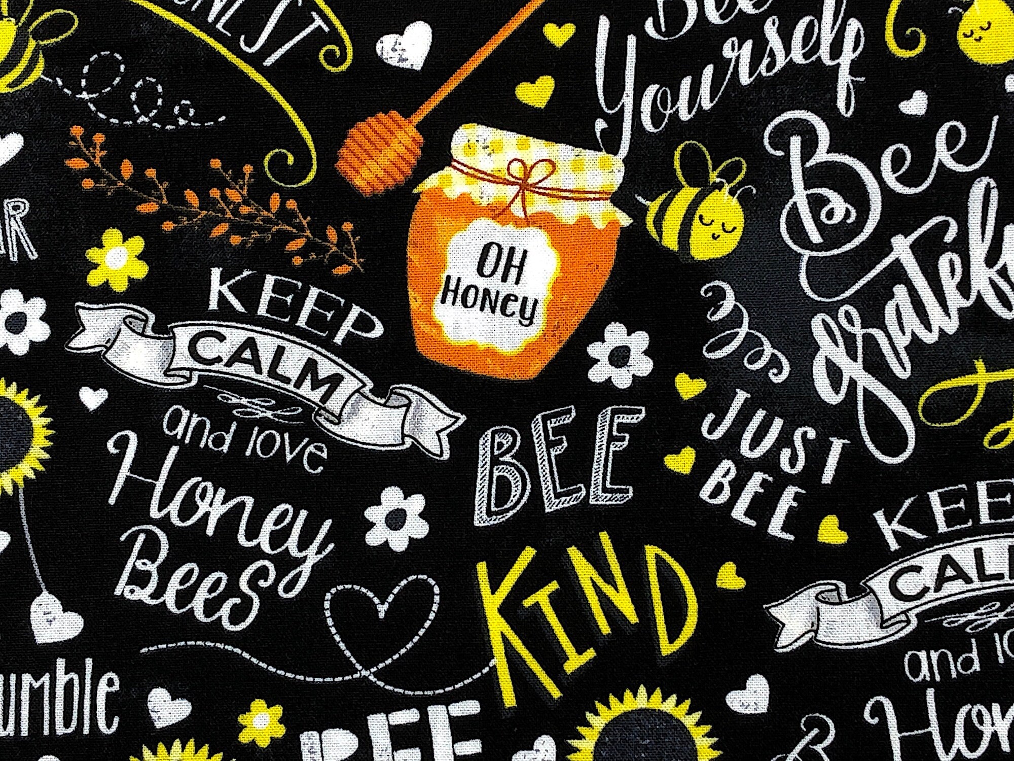 Close up of a jar of honey and sayings such as bee kind, just bee and more.