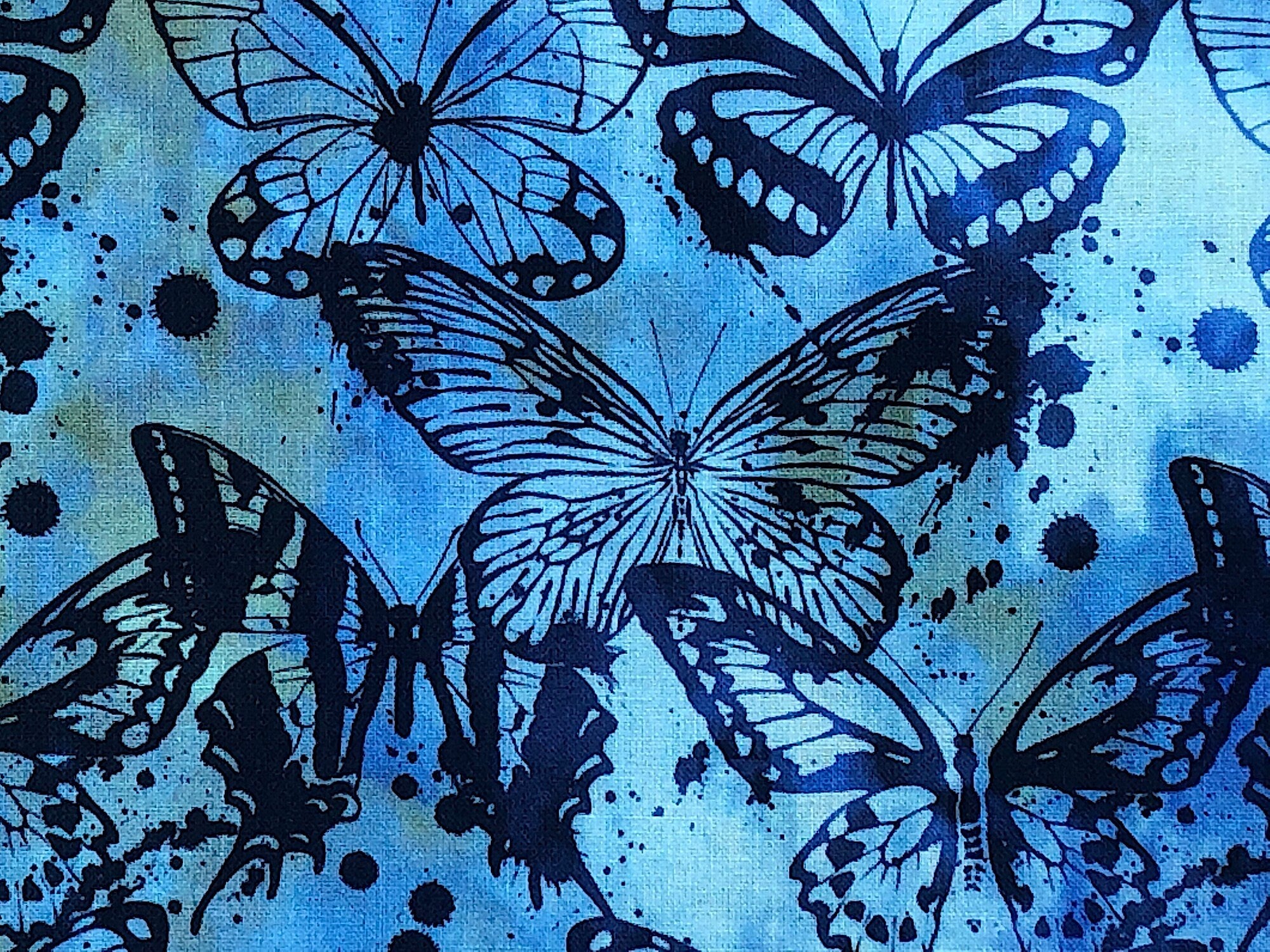 Close up of blue batik fabric covered with butterflies.