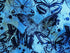 Close up of blue batik fabric covered with butterflies.