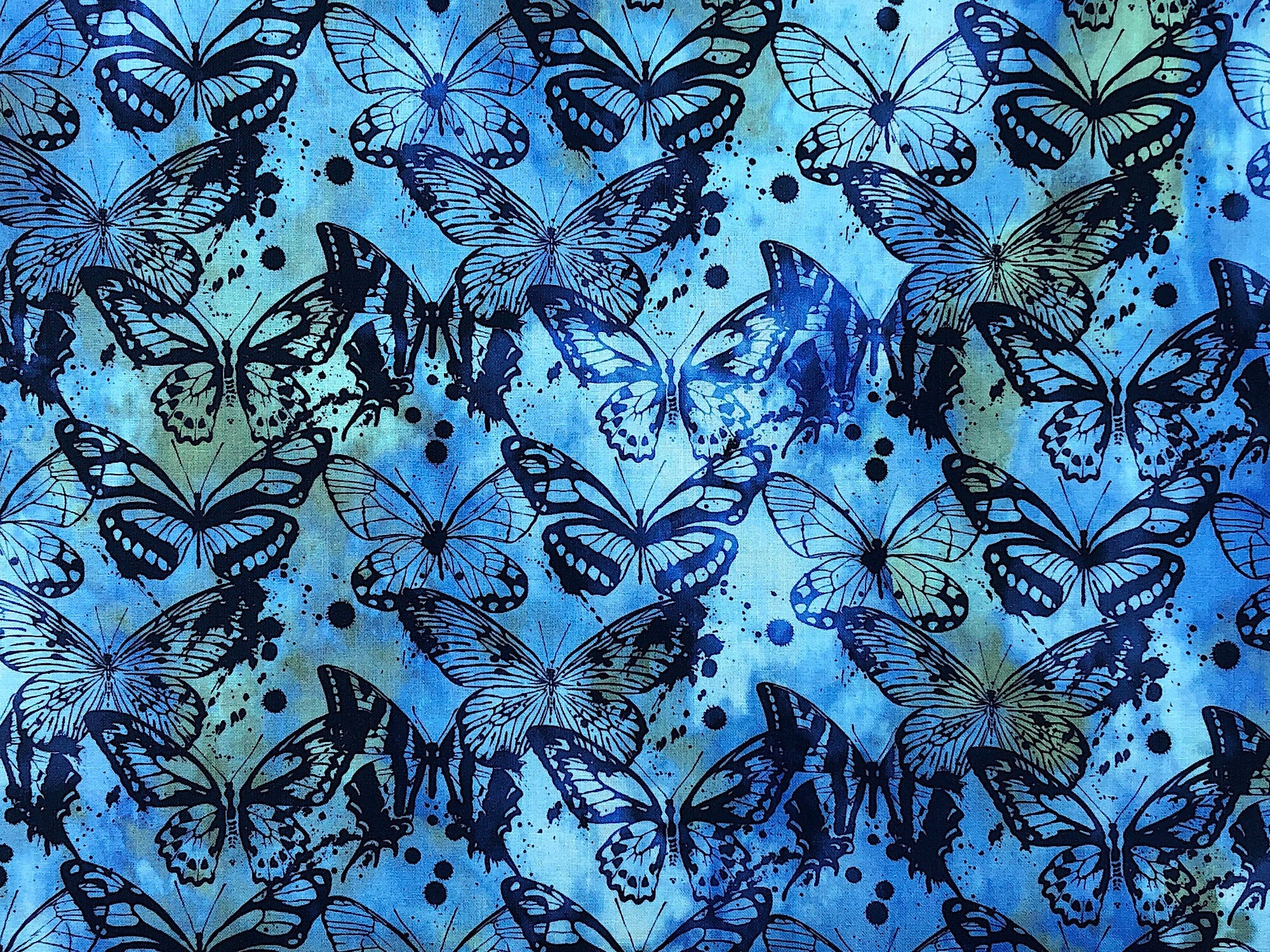 This batik fabric is called Seasons and is covered with butterflies. The background has a mixture of blue and greens in various shades