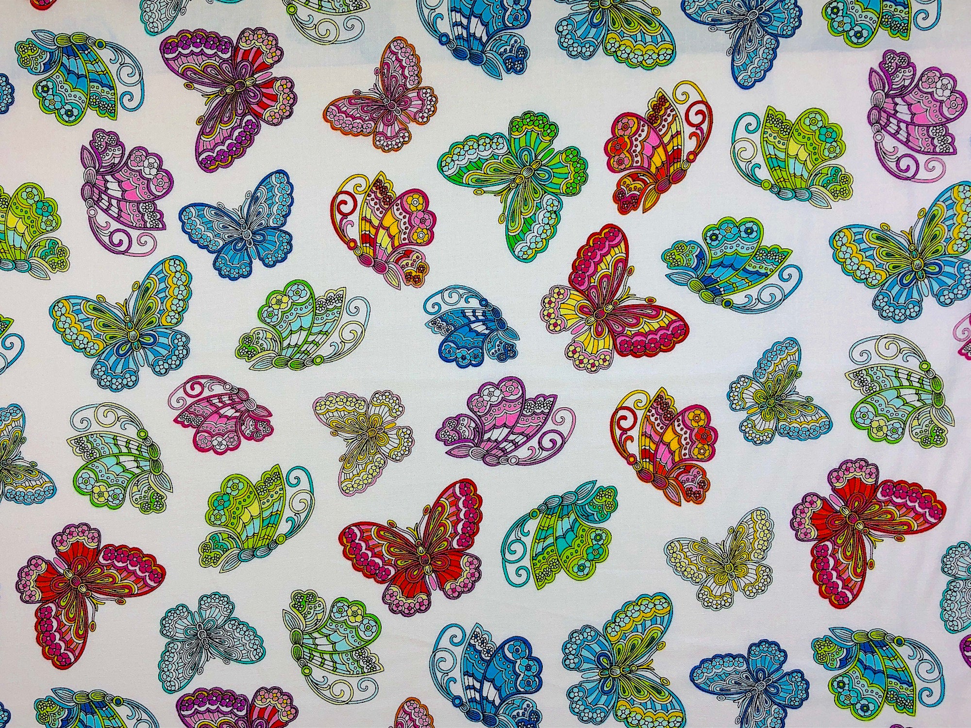 This white fabric is part of the Dazzling Garden Collection and is covered with butterflies. The butterflies are blue, green red, yellow, pink and orange.