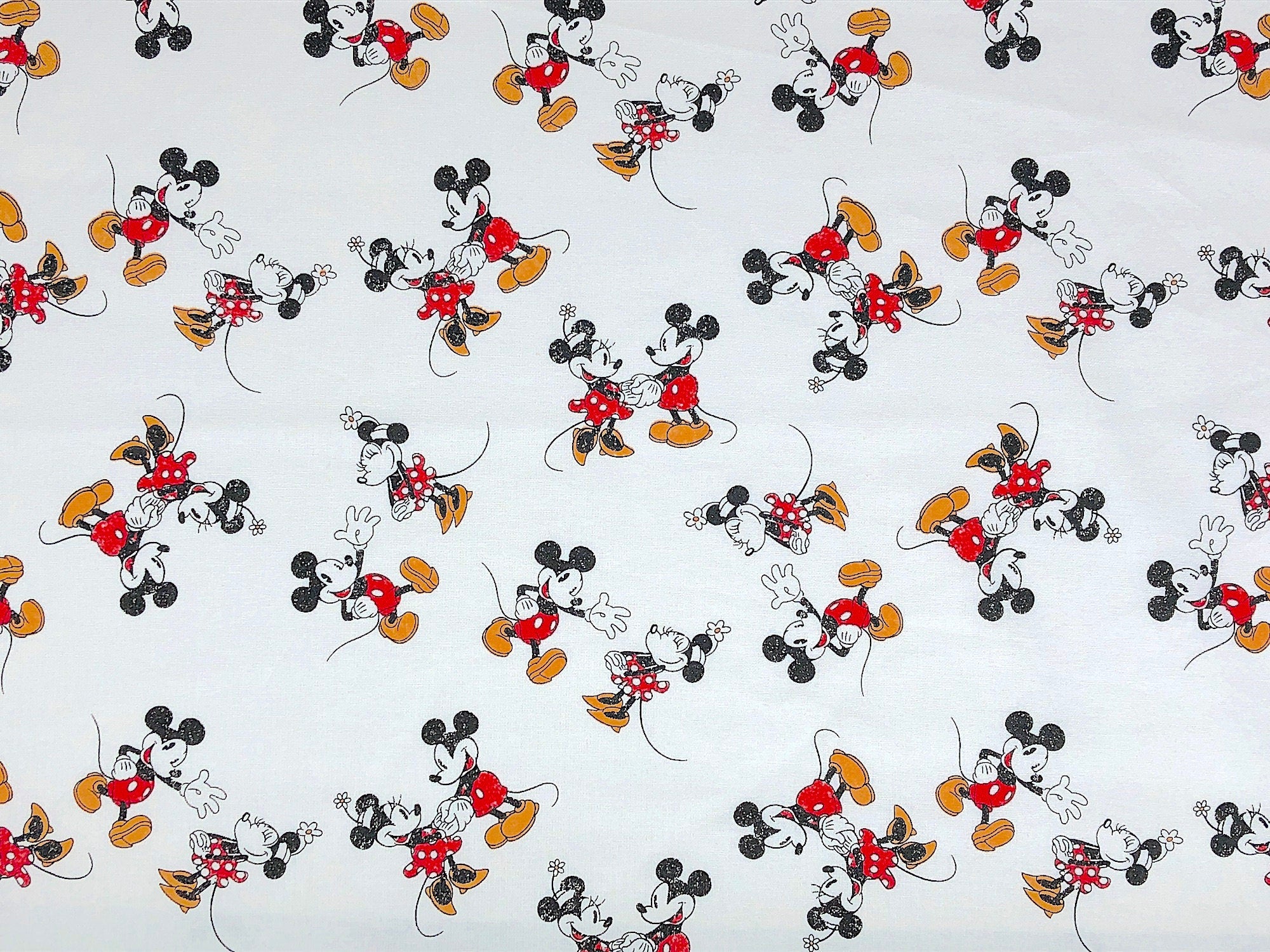 This fabric is called Mickey Minnie Scattered. This white fabric is covered with Mickey and Minnie Mouse