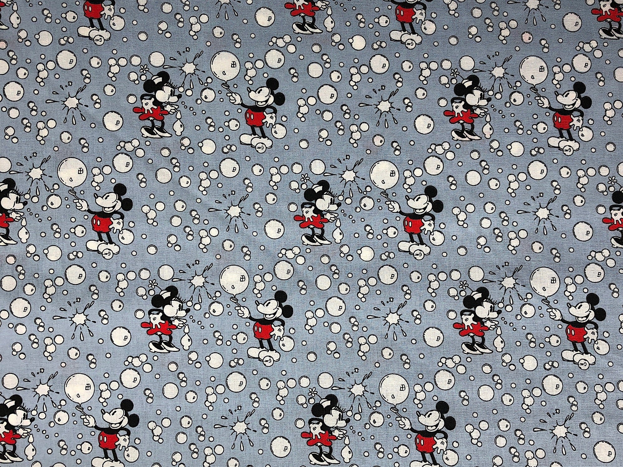 This grey fabric is called Mickey and Minnie Bubbles. Mickey Mouse and Minnie Mouse are surrounded by bubbles. 
